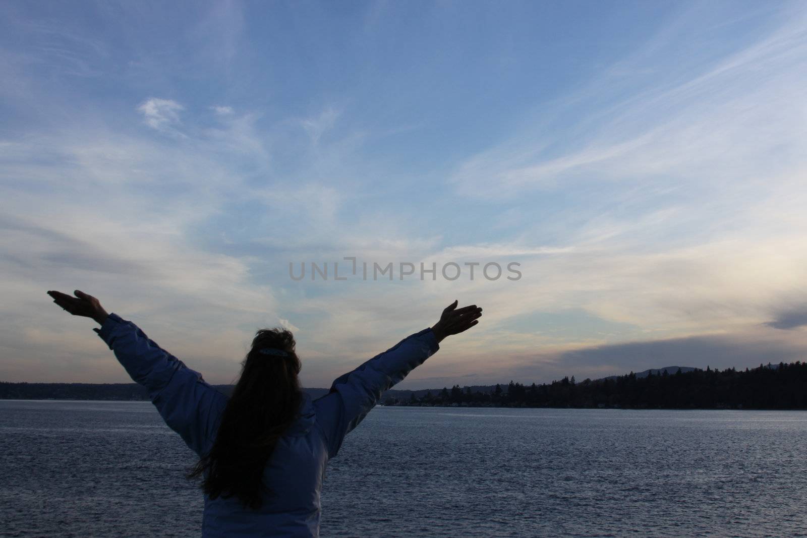 Person on the ferry rejoicing at the sunset.