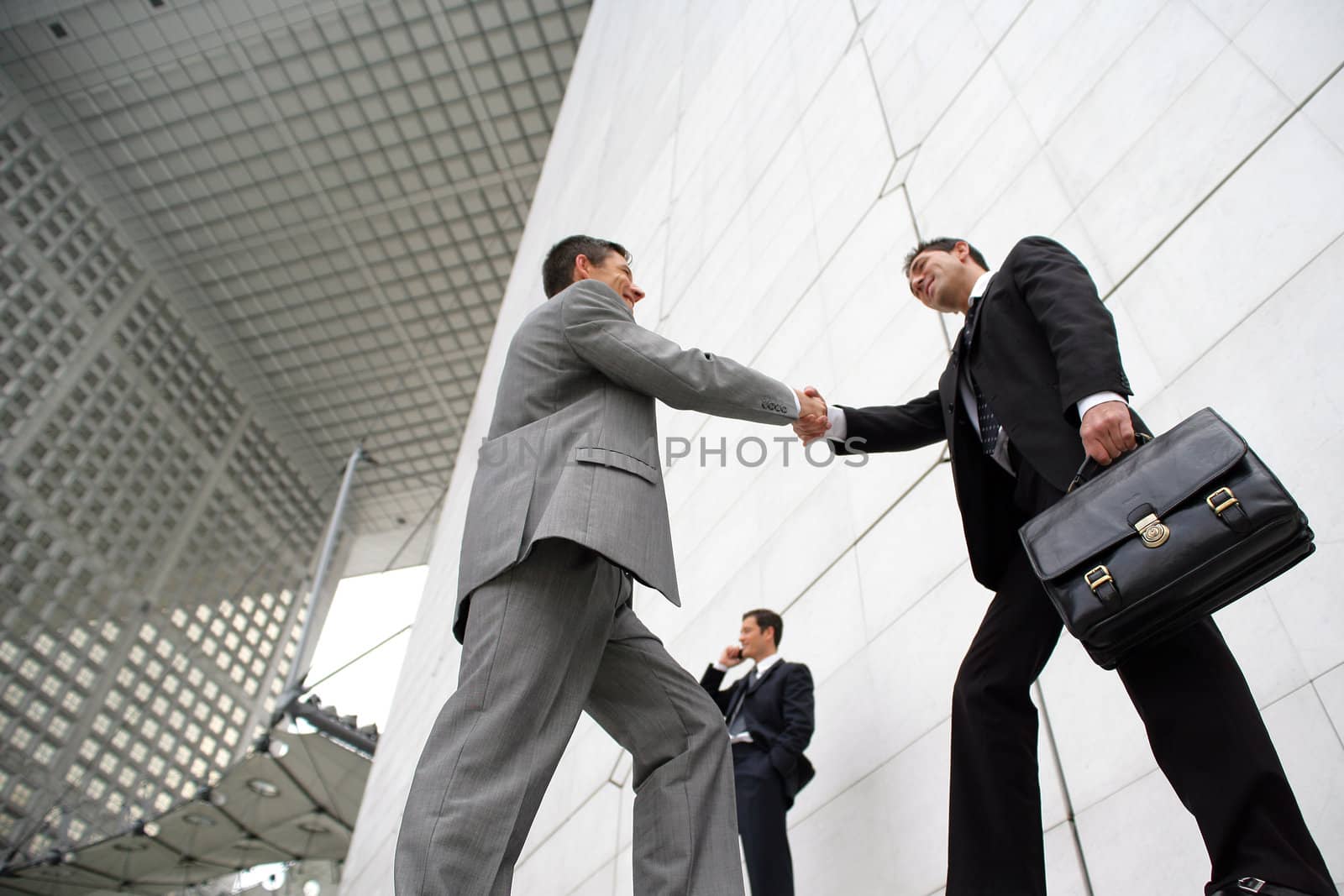 Businessmen shaking hands outside