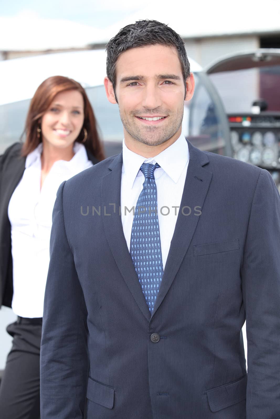 Businessman standing with a woman and light aircraft