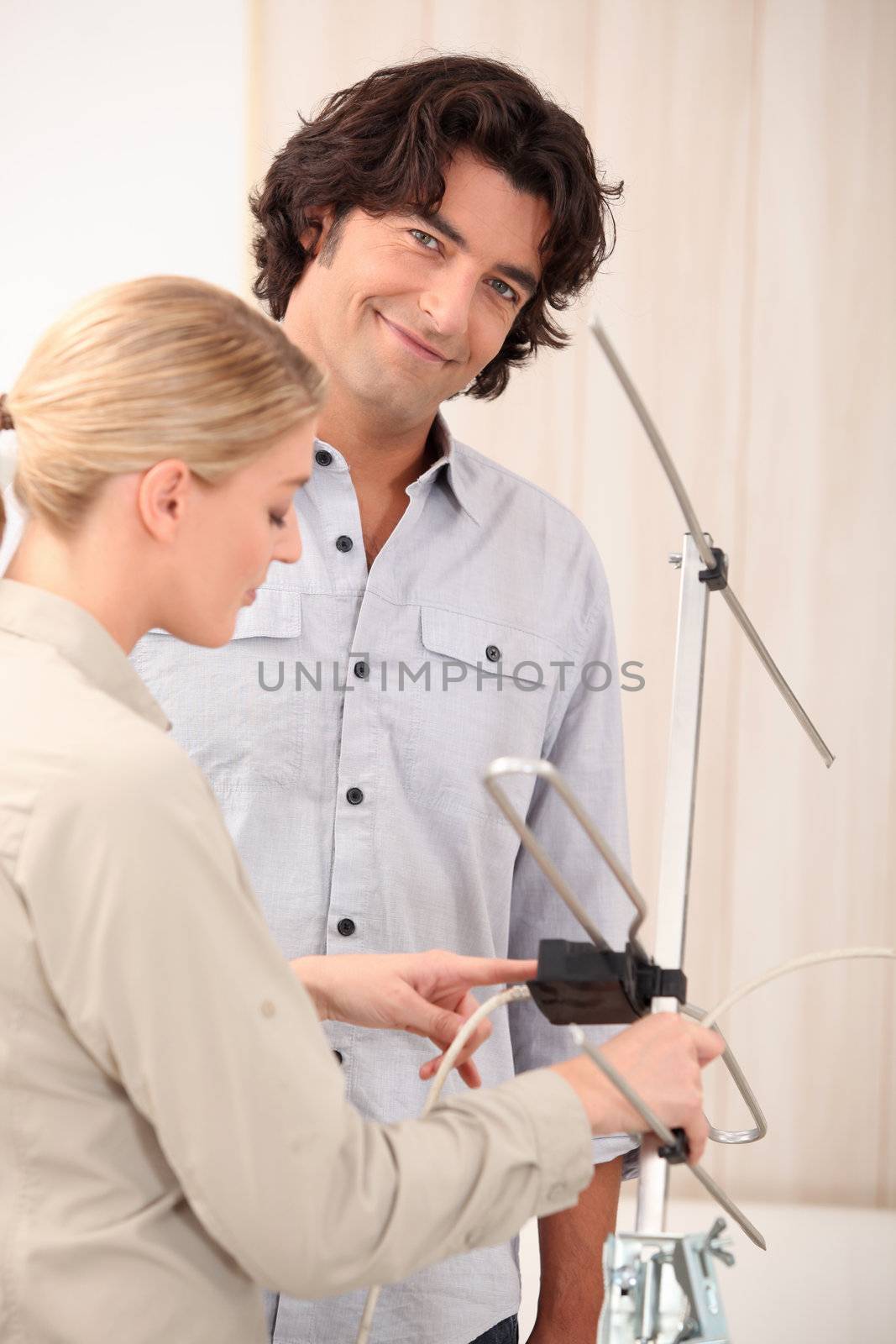 Couple fixing television aerial by phovoir