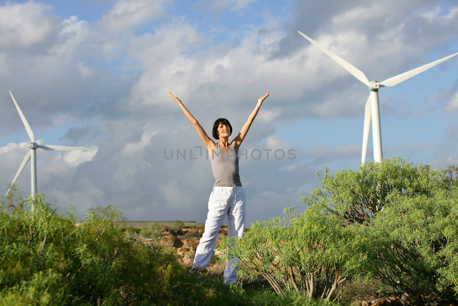 Woman in front of a wind farm by phovoir