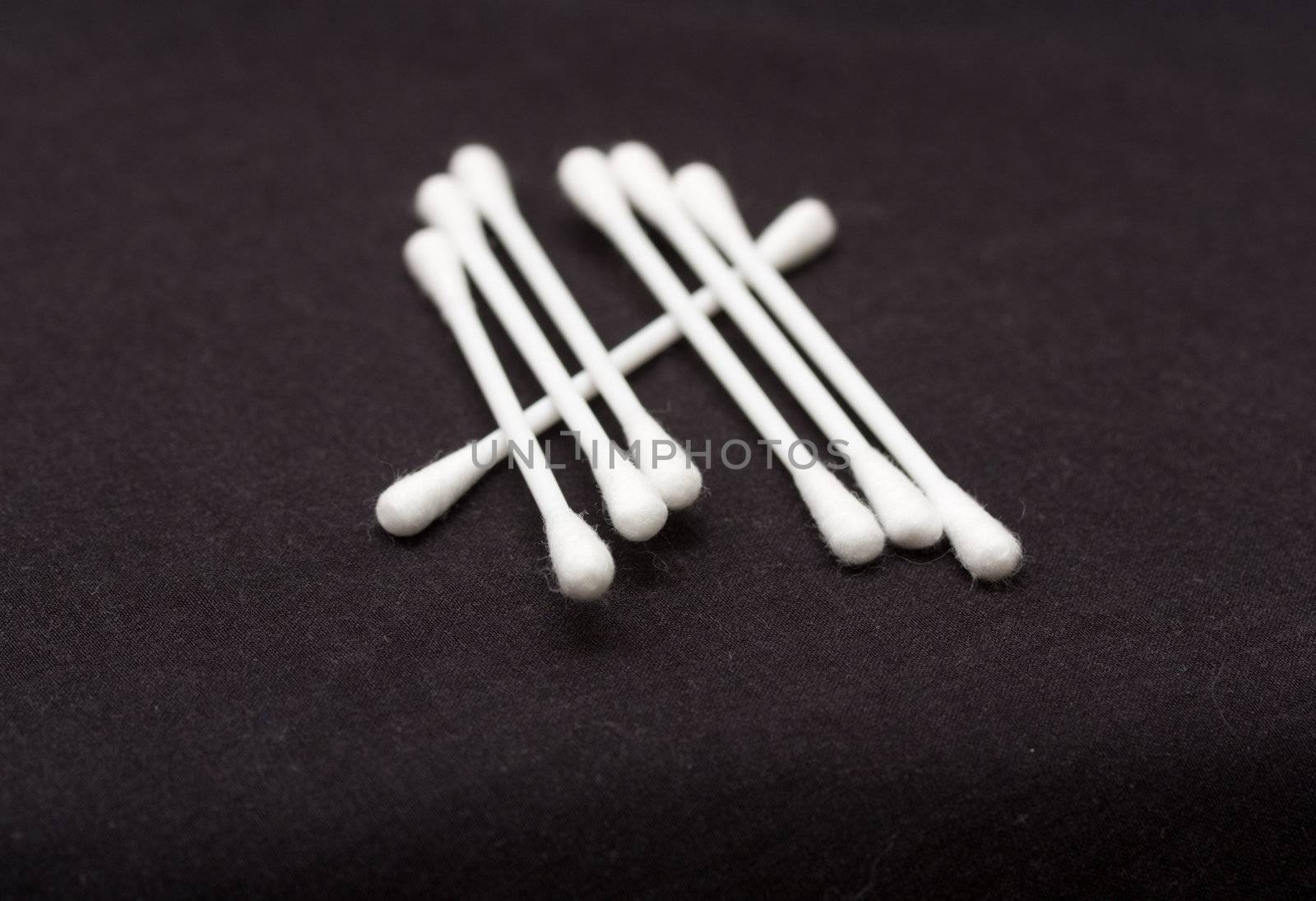 Cotton sticks isolated on black background  by schankz