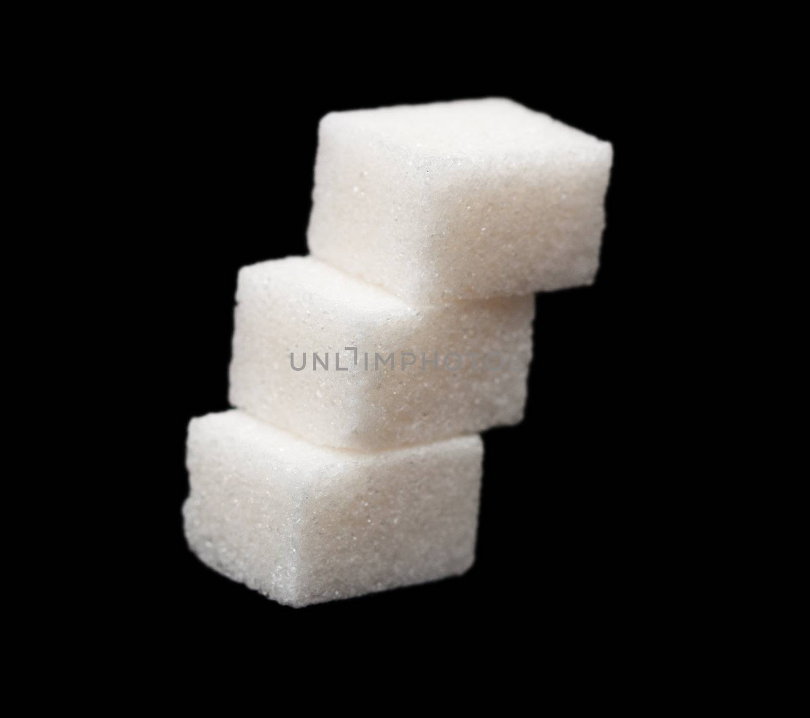 three lumps of sugar on a black background