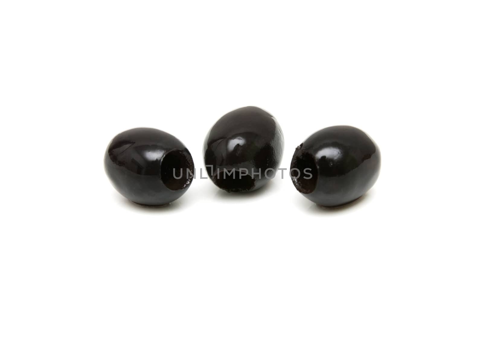 Three black olives shot on white background 
