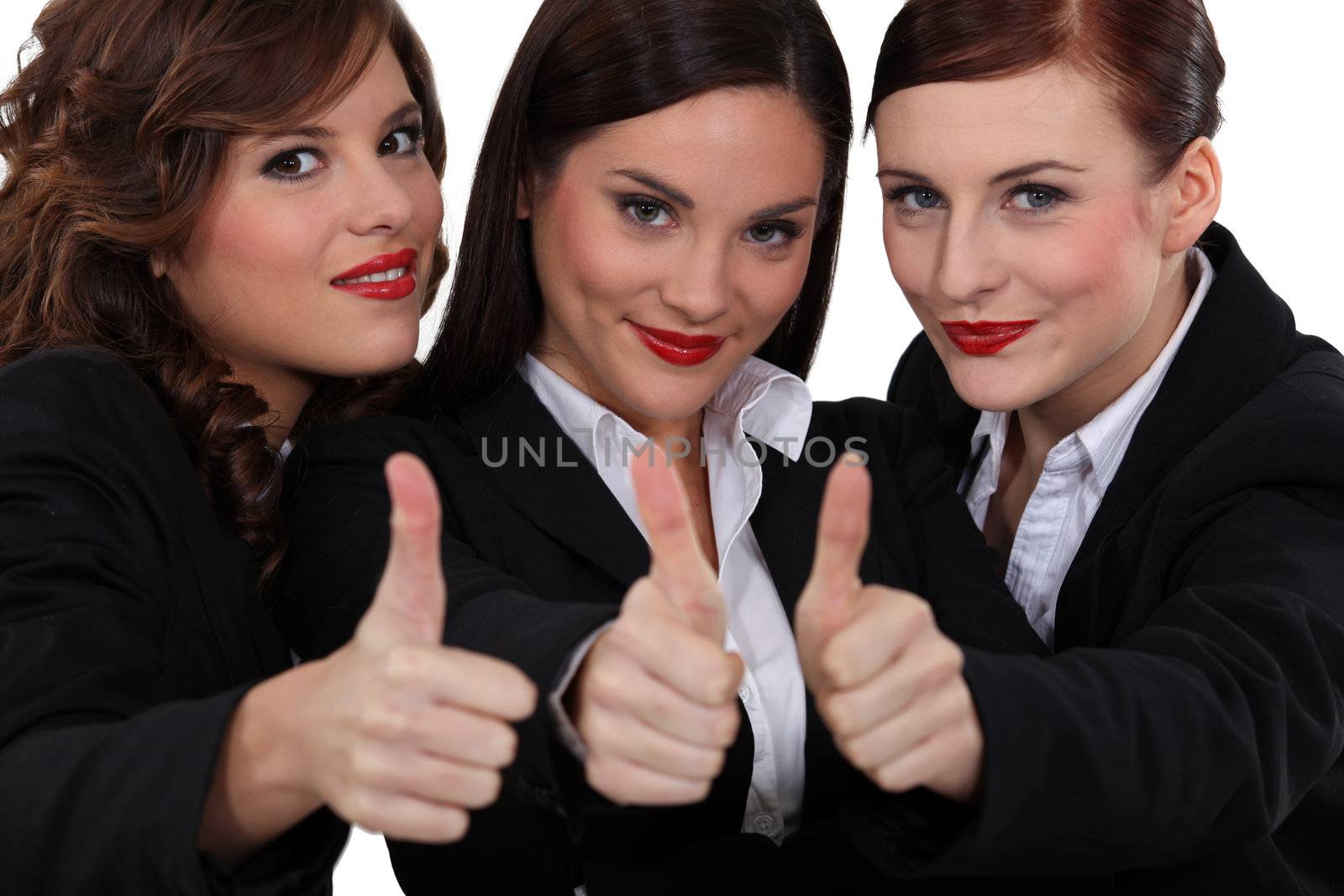 Three businesswomen giving the thumb up.
