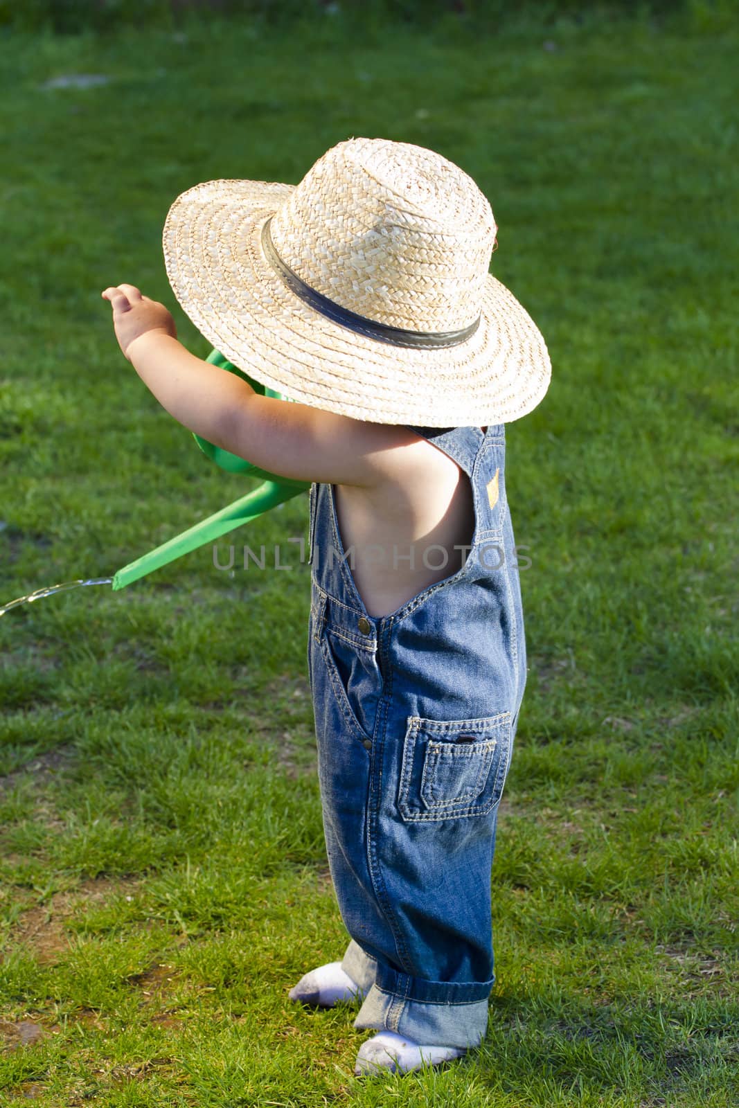 A boy with straw hat, a young gardener enjoying the spring