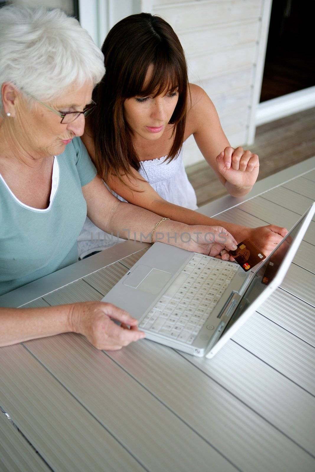 Young woman teaching her grandmother computer skills