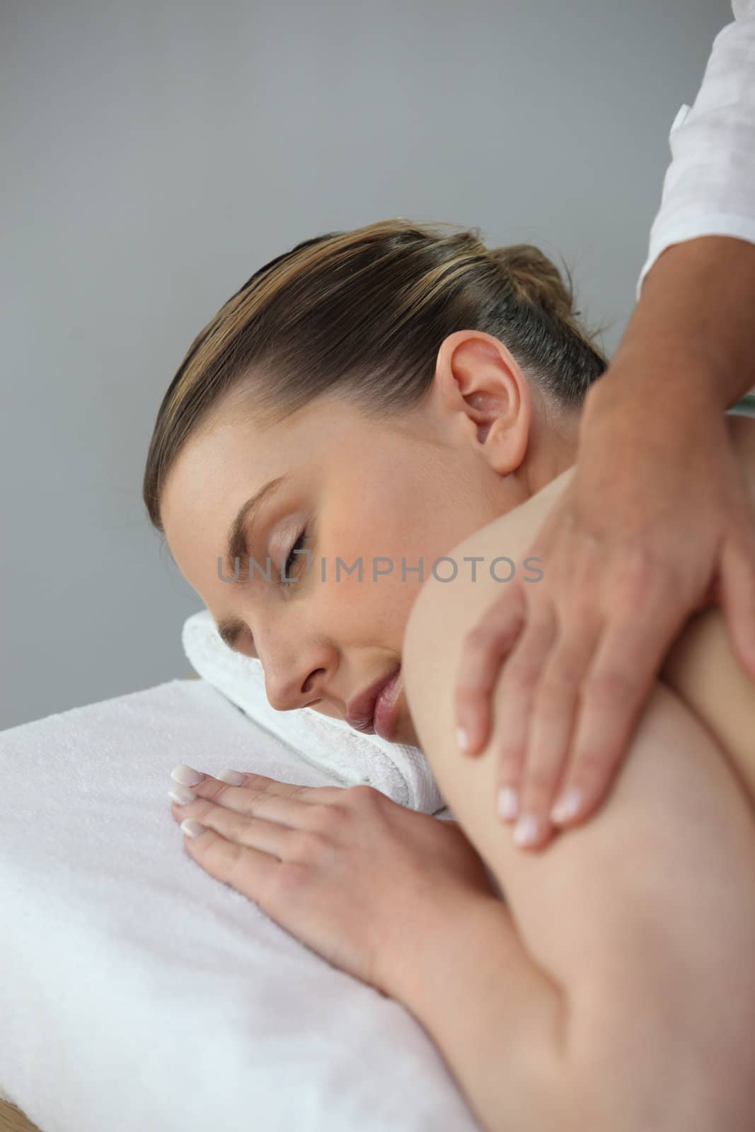 Young woman being massaged in beauty parlor by phovoir