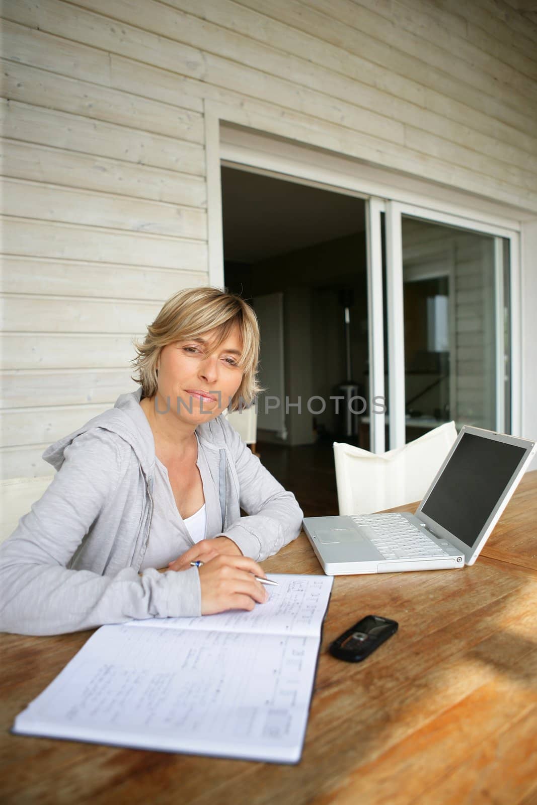 Woman using a laptop at home by phovoir