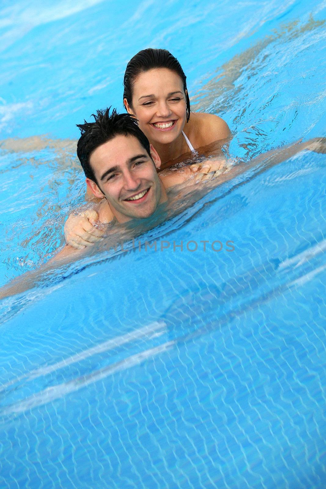 Couple swimming together in pool