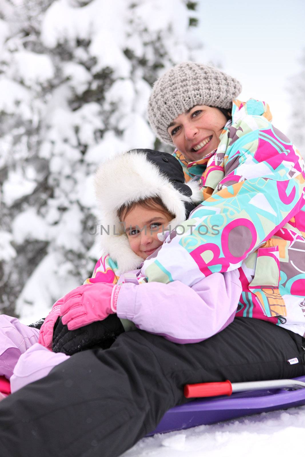 Mother and daughter sledging together