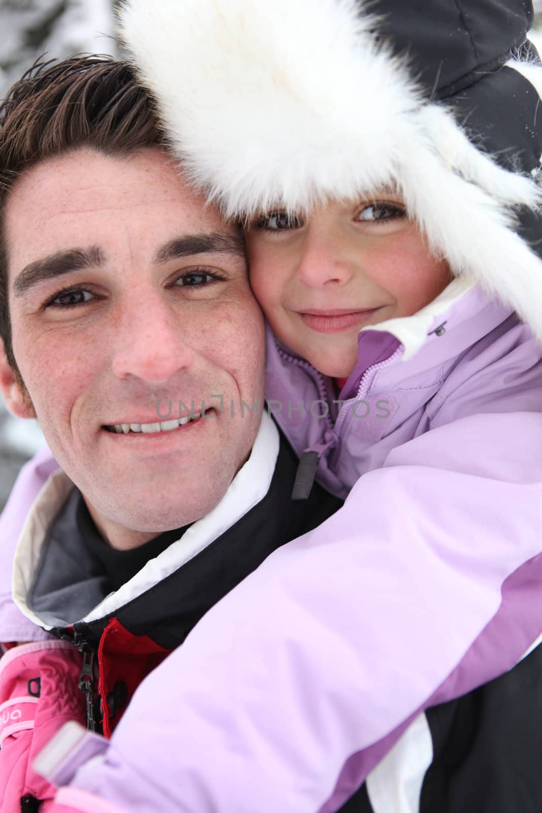 Young girl with her father on a winter's day by phovoir