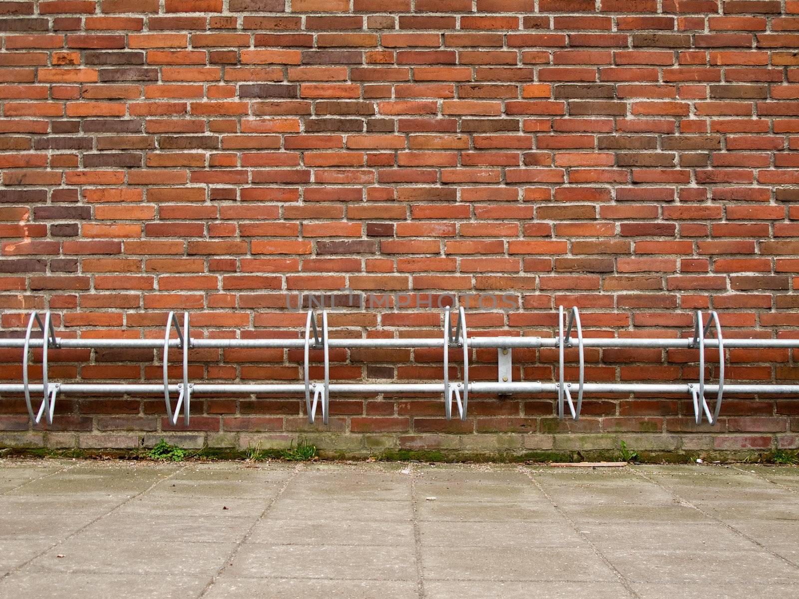 an empty bicycle rack on a brick wall simple structure
