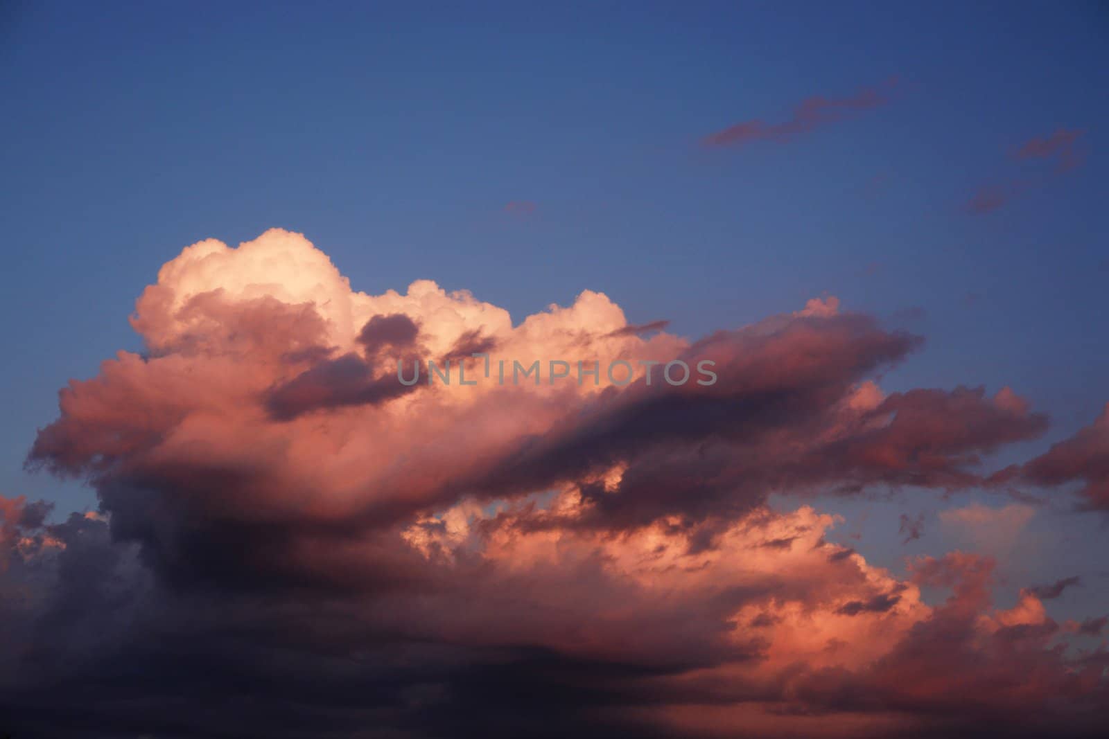 a huge storm lit by the setting sun.