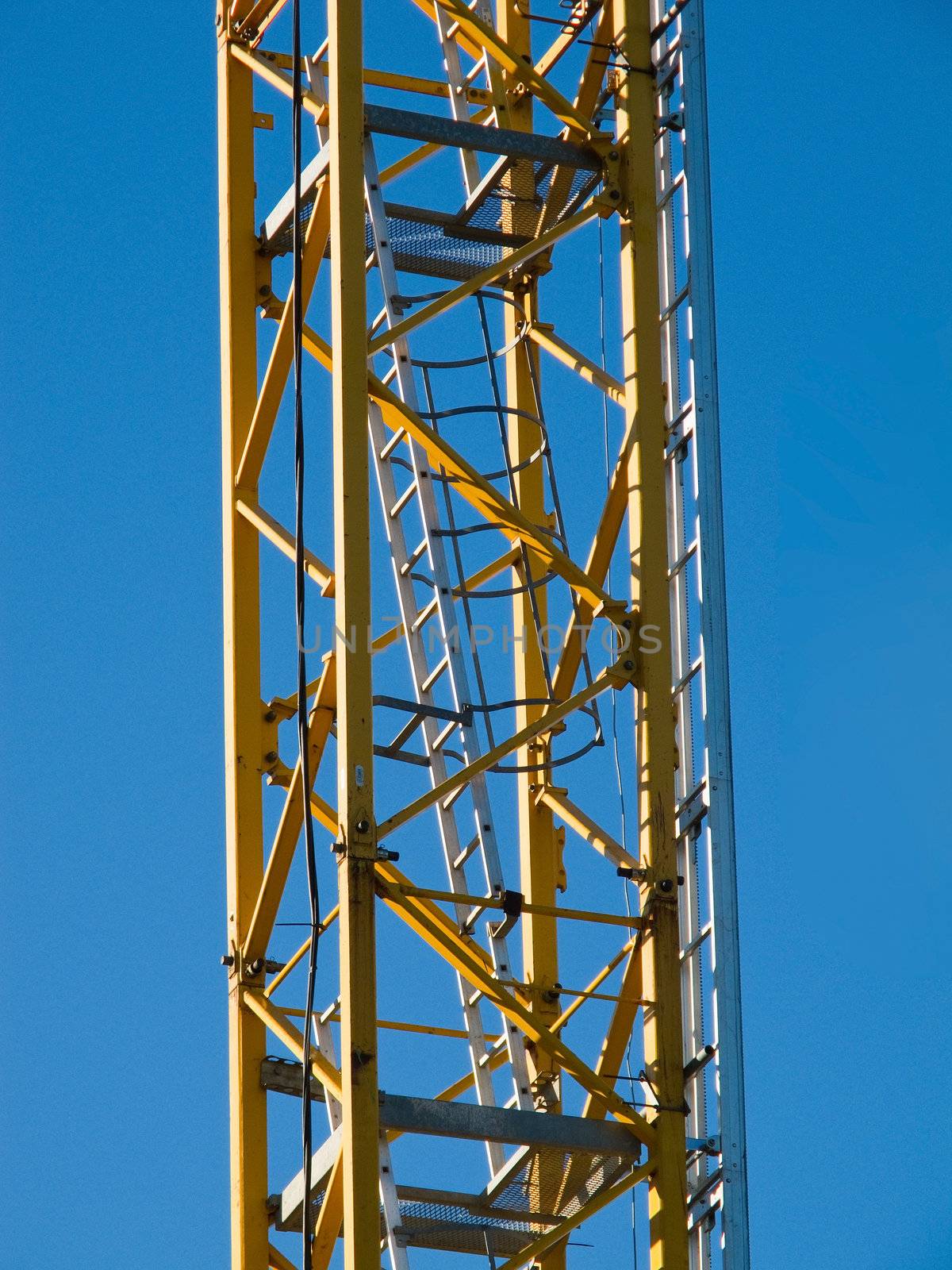 Detail of the stairs of a yellow hoisting tower crane