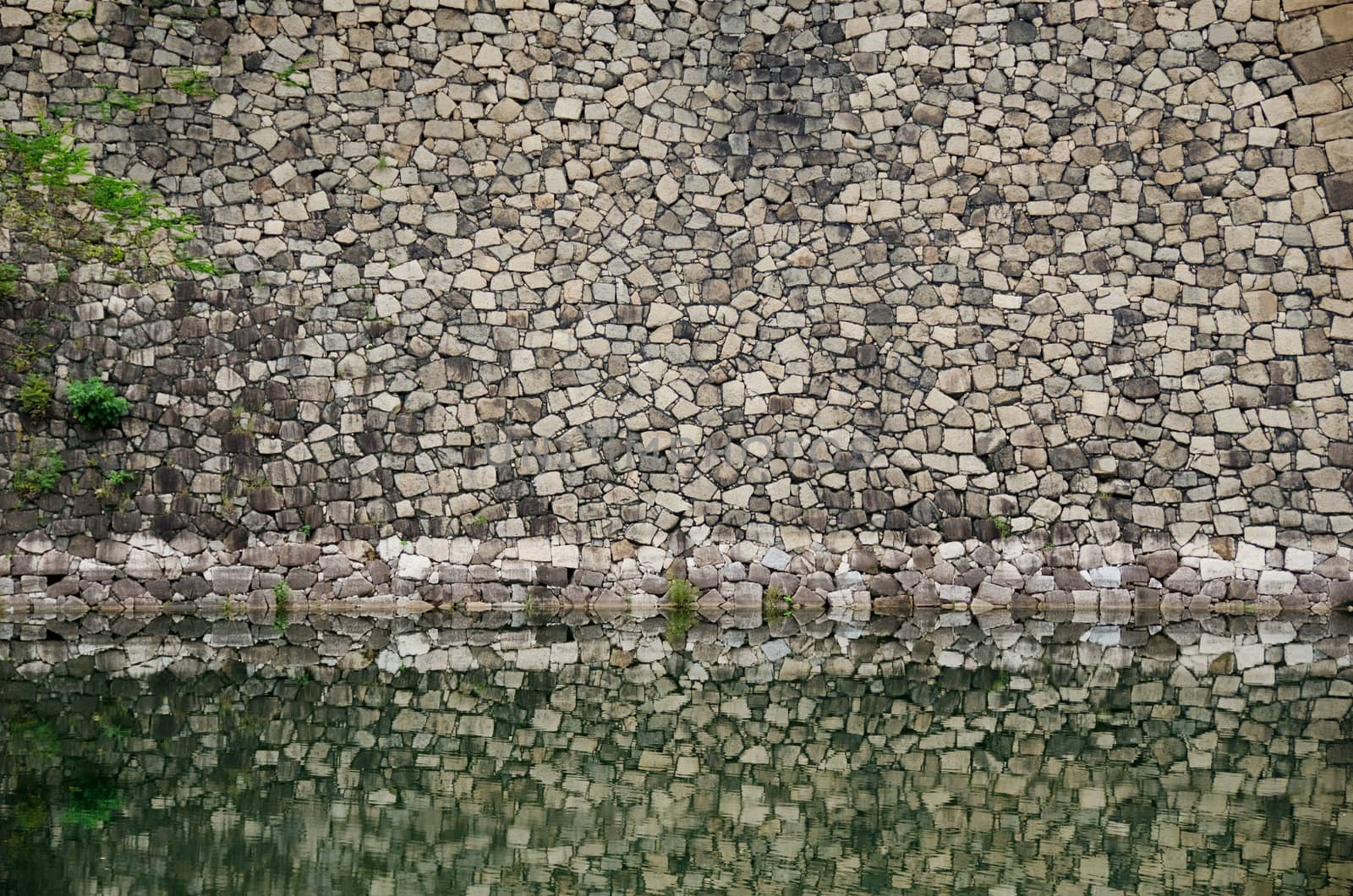 Strong castle fortification wall mirrored in water