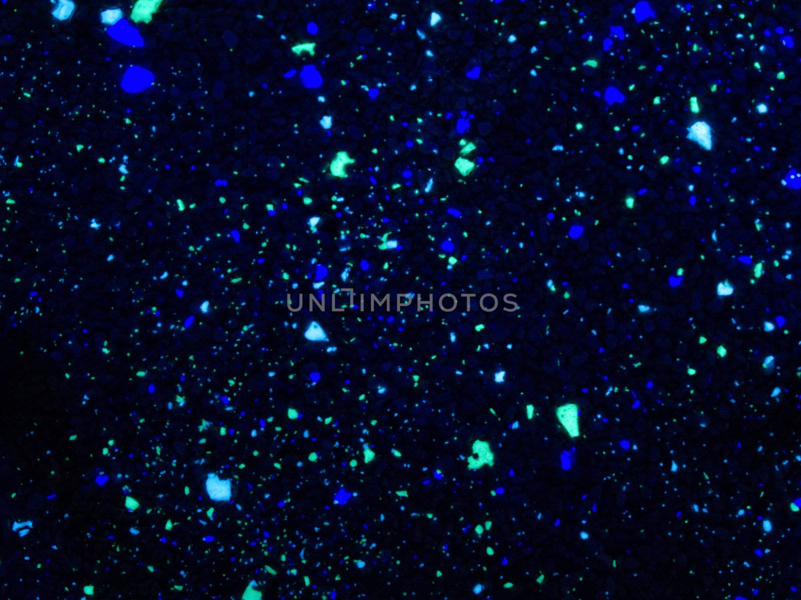 Spots of fluorescent stones in a pavement background pattern