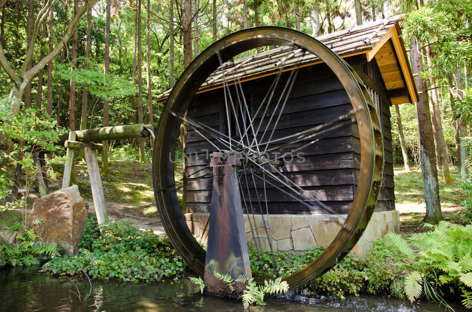 Small Japanese water mill running in the Expo Commemorative Park, Osaka