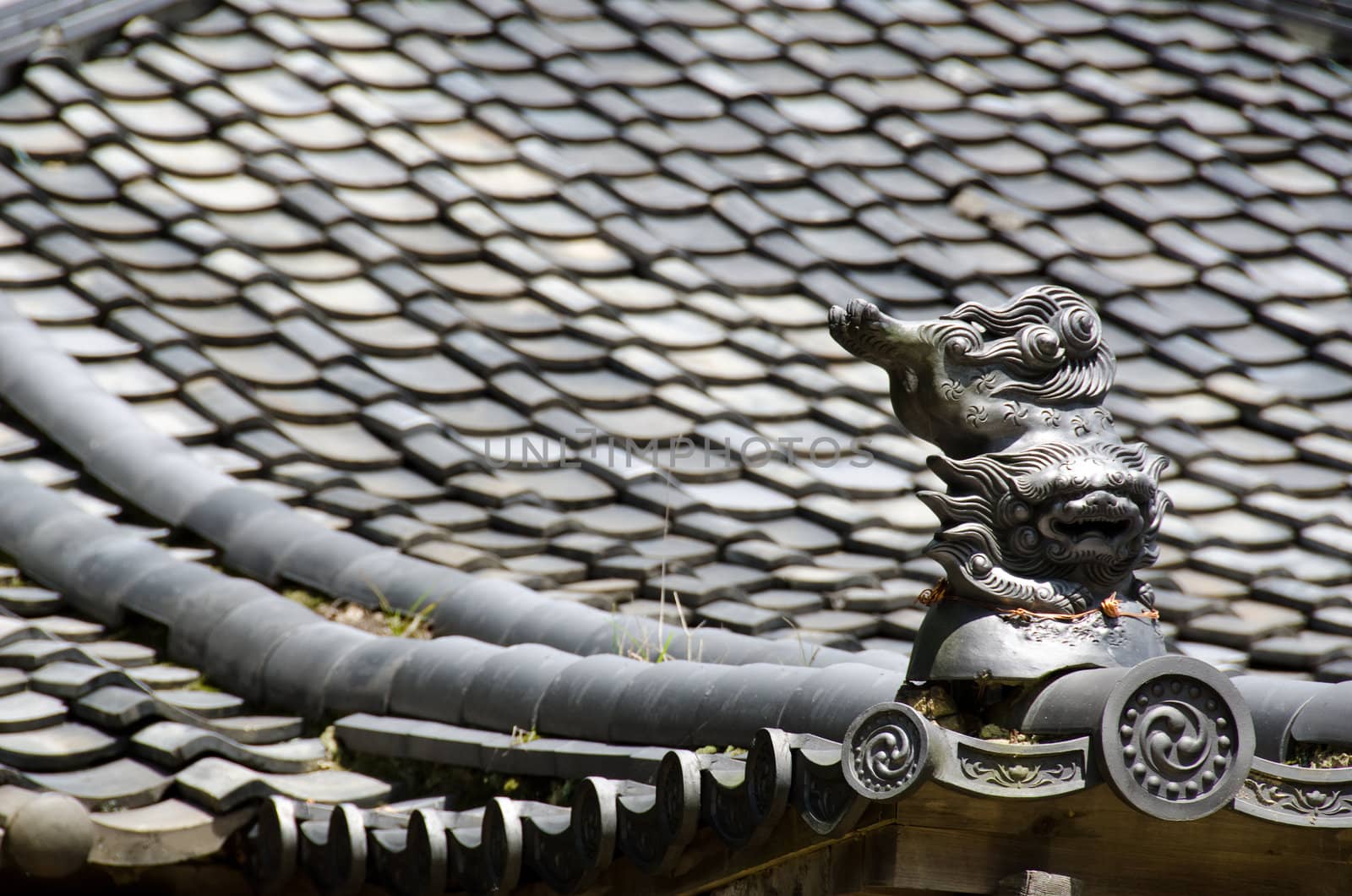 Detail of the roof of a japanese temple with Komainu figure