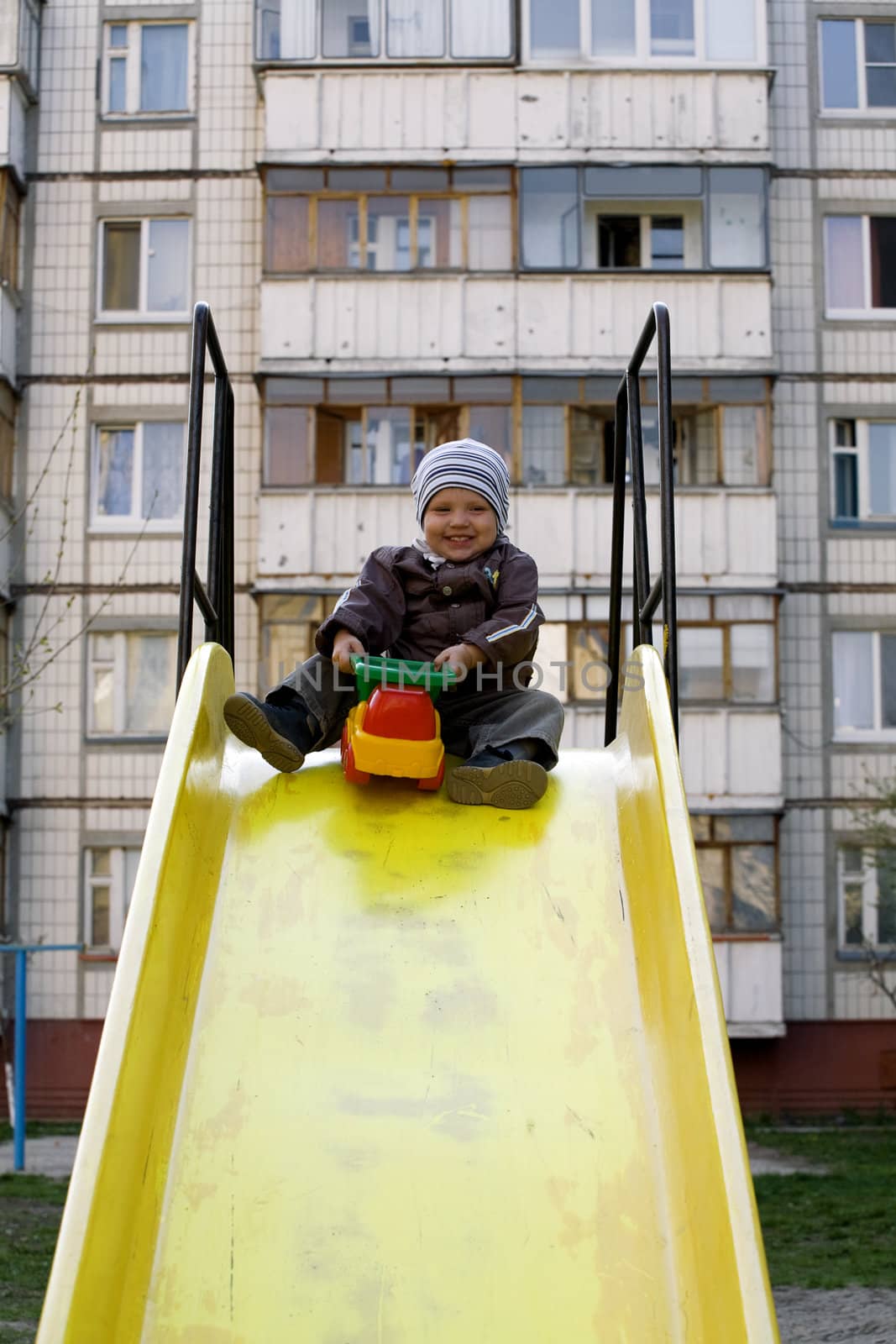 boy playing with a baby car on a backs in an autumn season