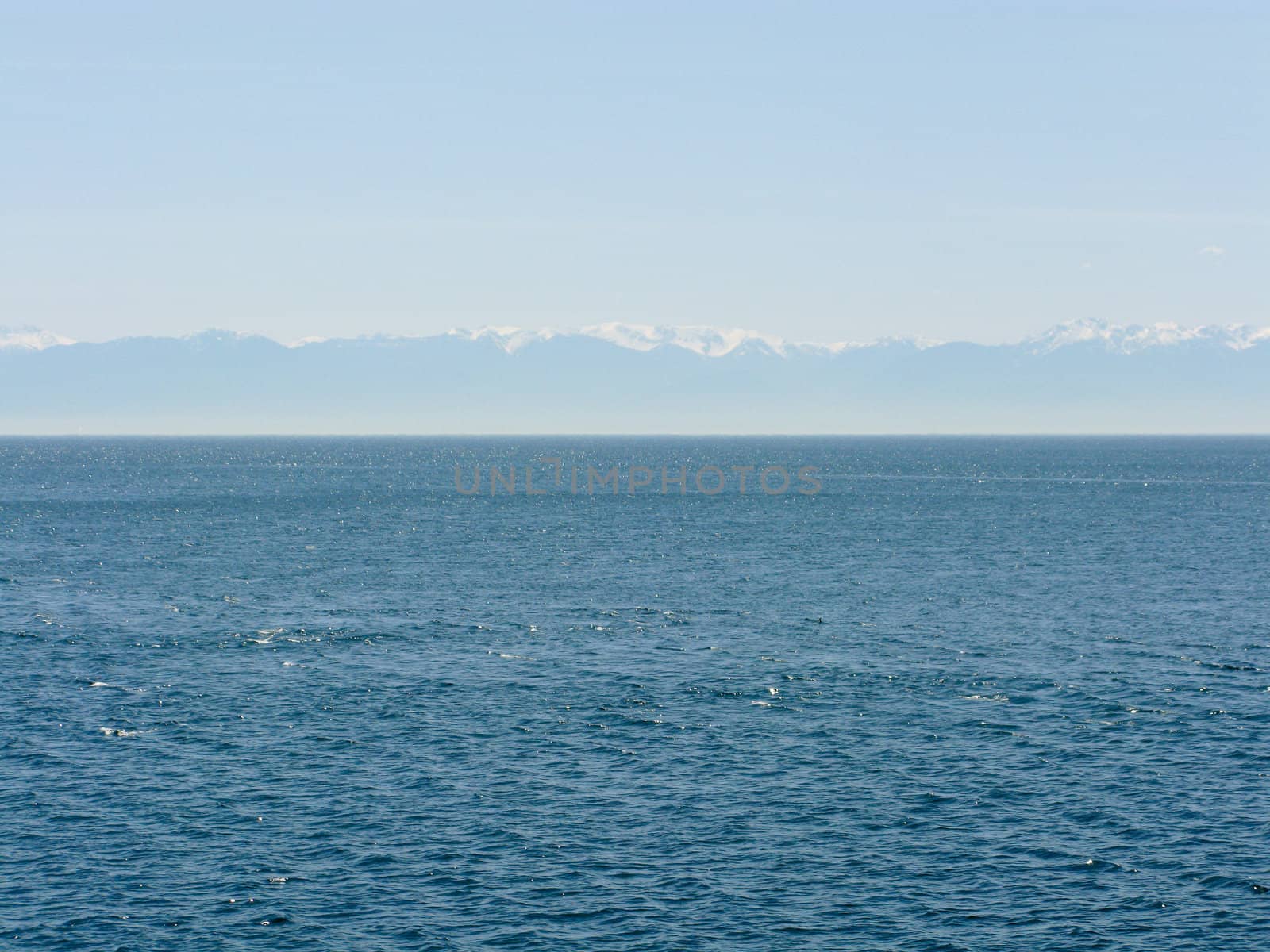 wide view over the sea with mountains in the background