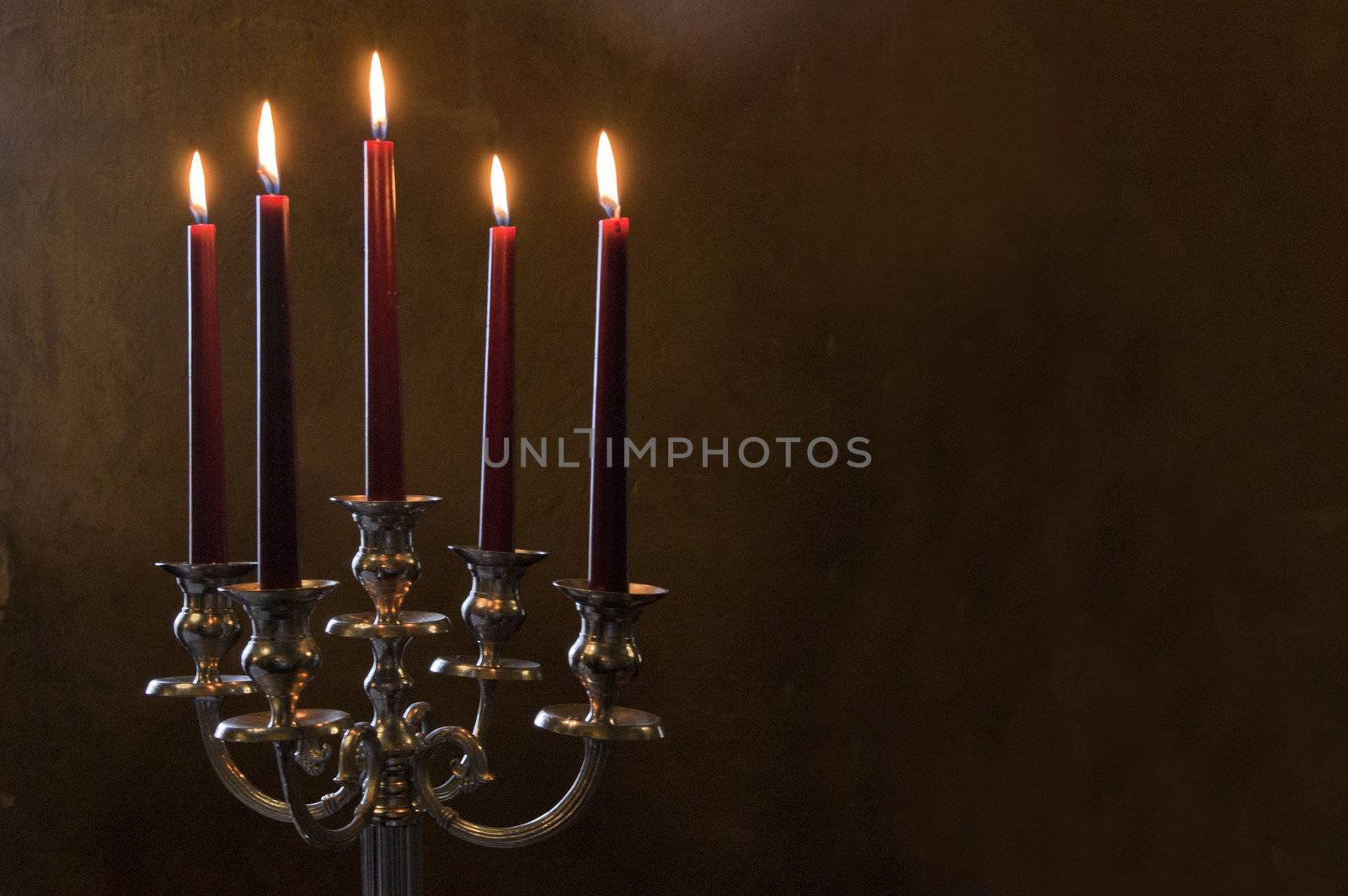 Five red candles lighted on brown painted room
