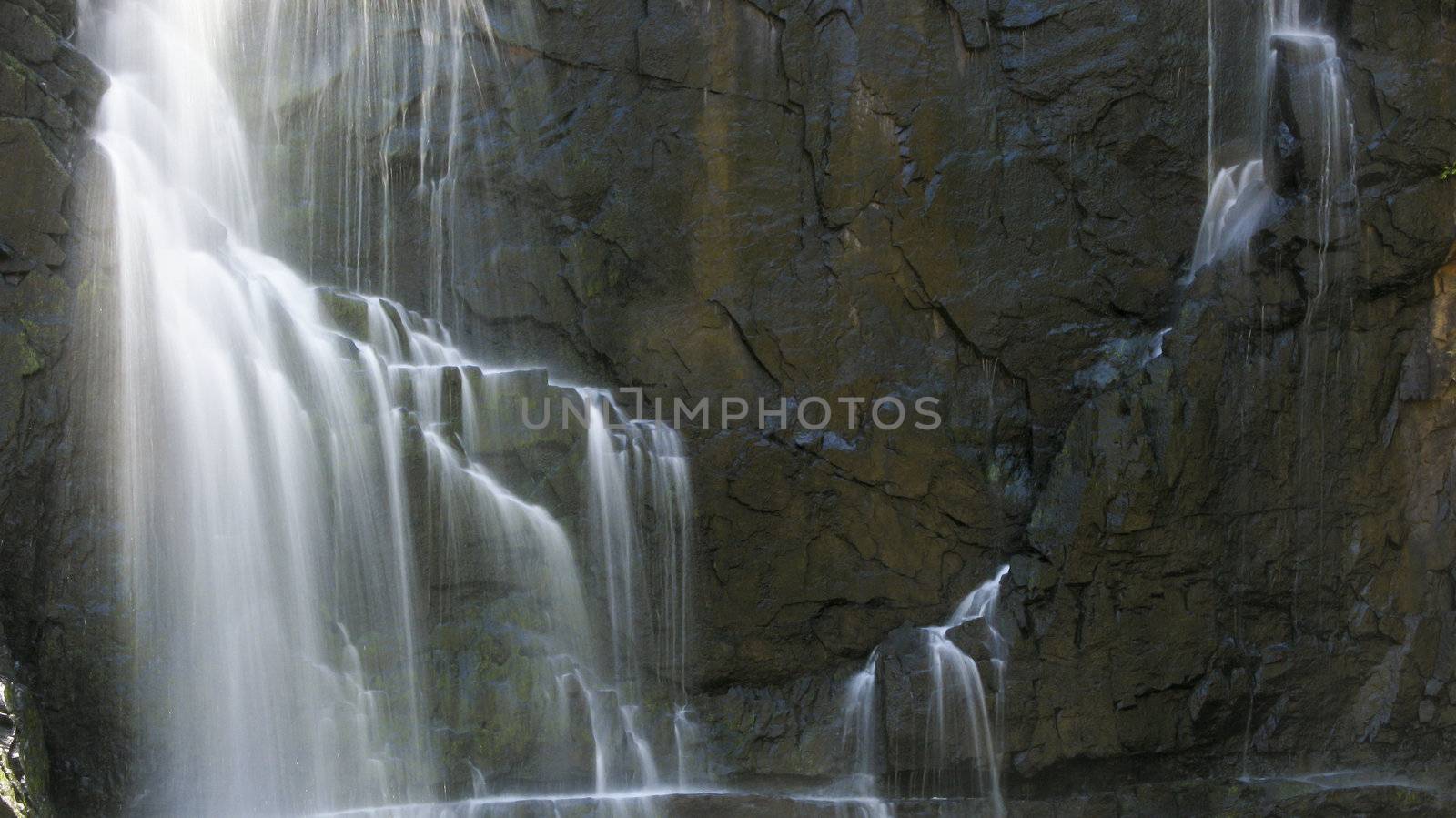 detail of a waterfall in long exposure and rocky background