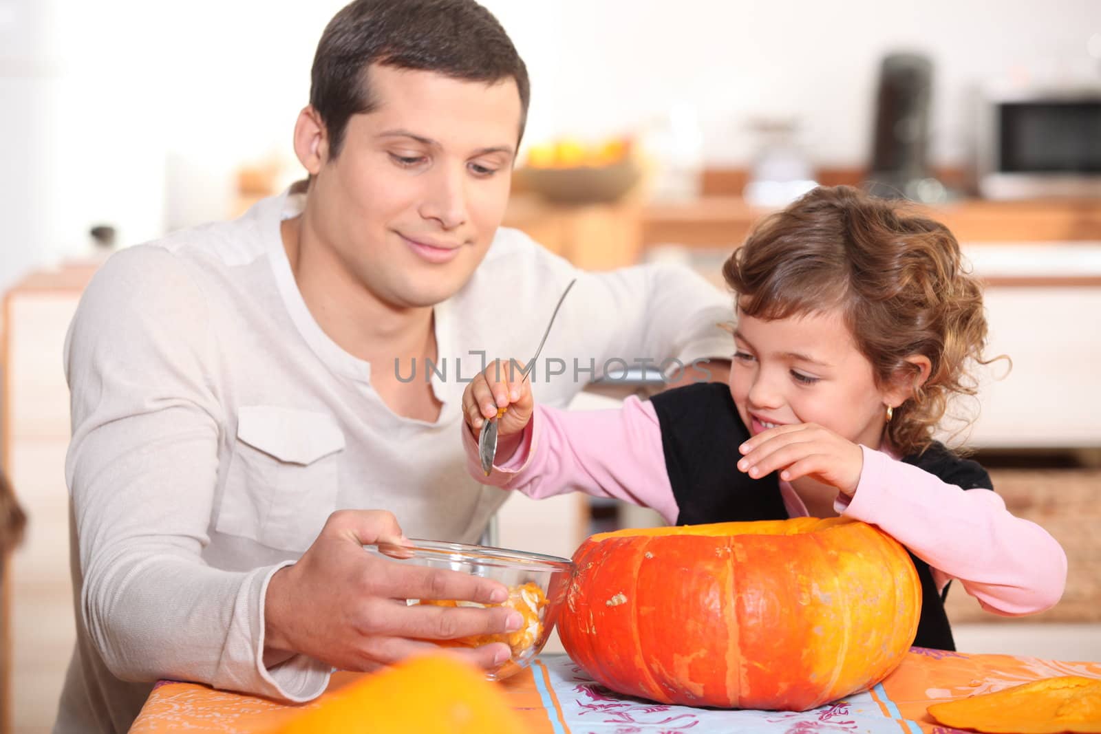 Dad and daughter hollowing out a pumpkin
