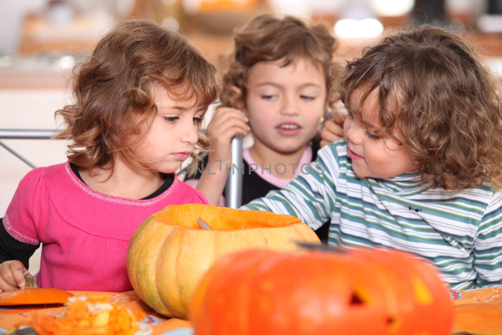 Kids preparing pumpkins for Halloween by phovoir