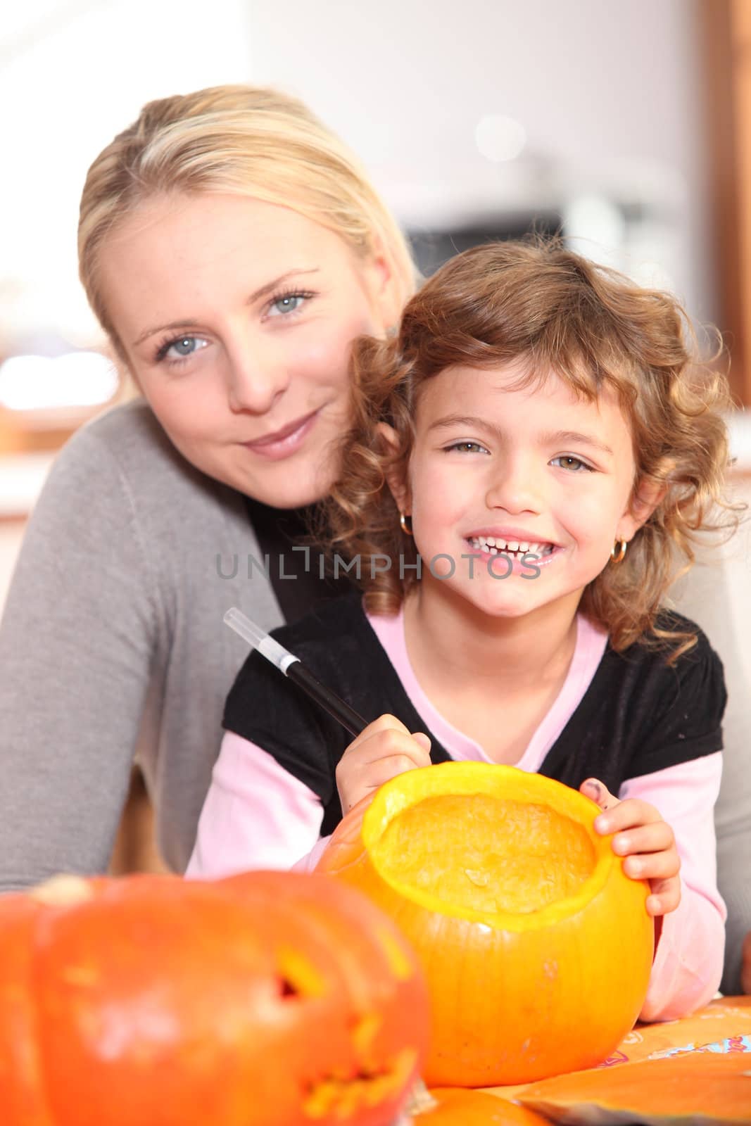 Girl decorating pumpkin by phovoir