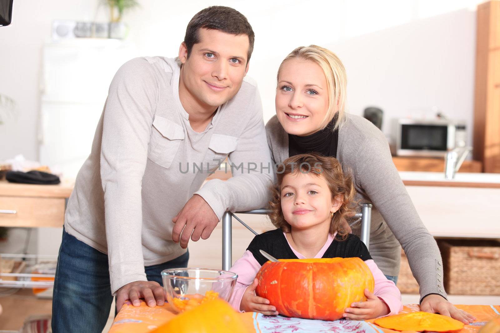Parents with a child and pumpkin by phovoir
