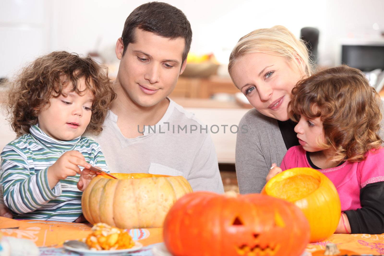 two parents and their two children celebrating Halloween