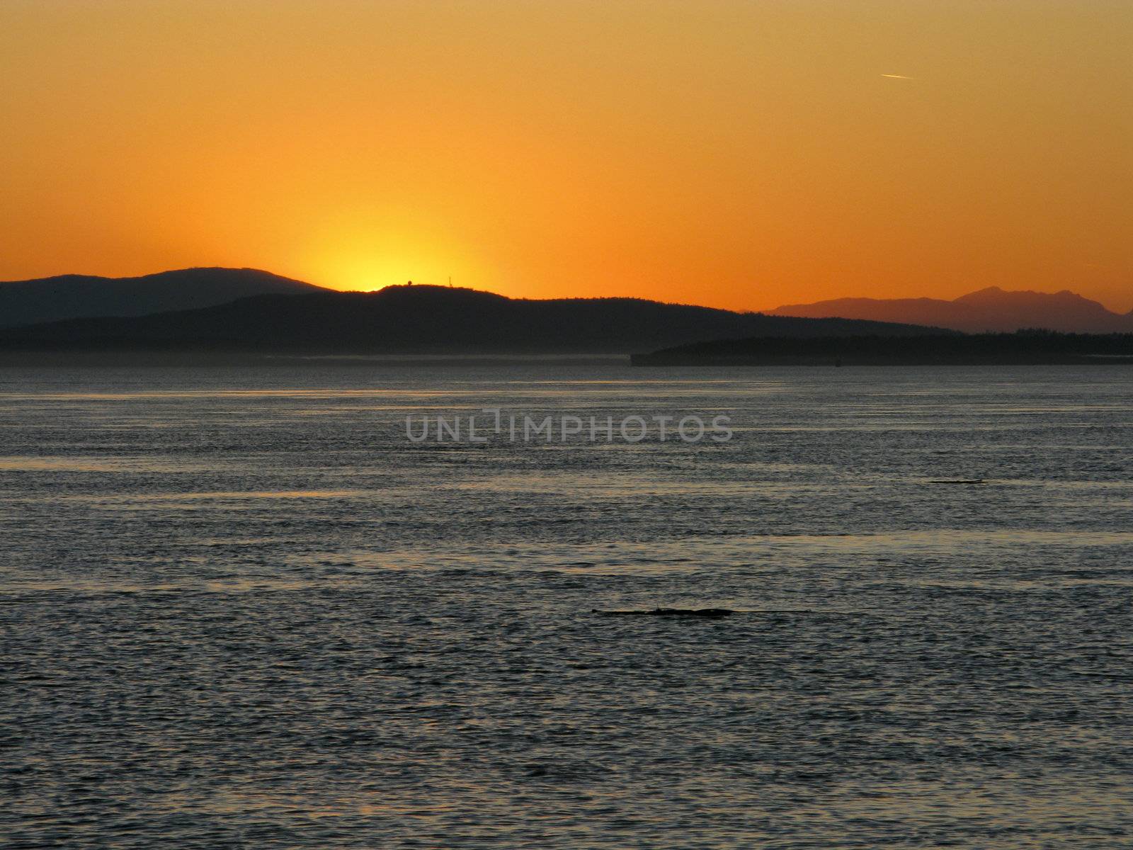 Sunset over the pacific with mountain range in background