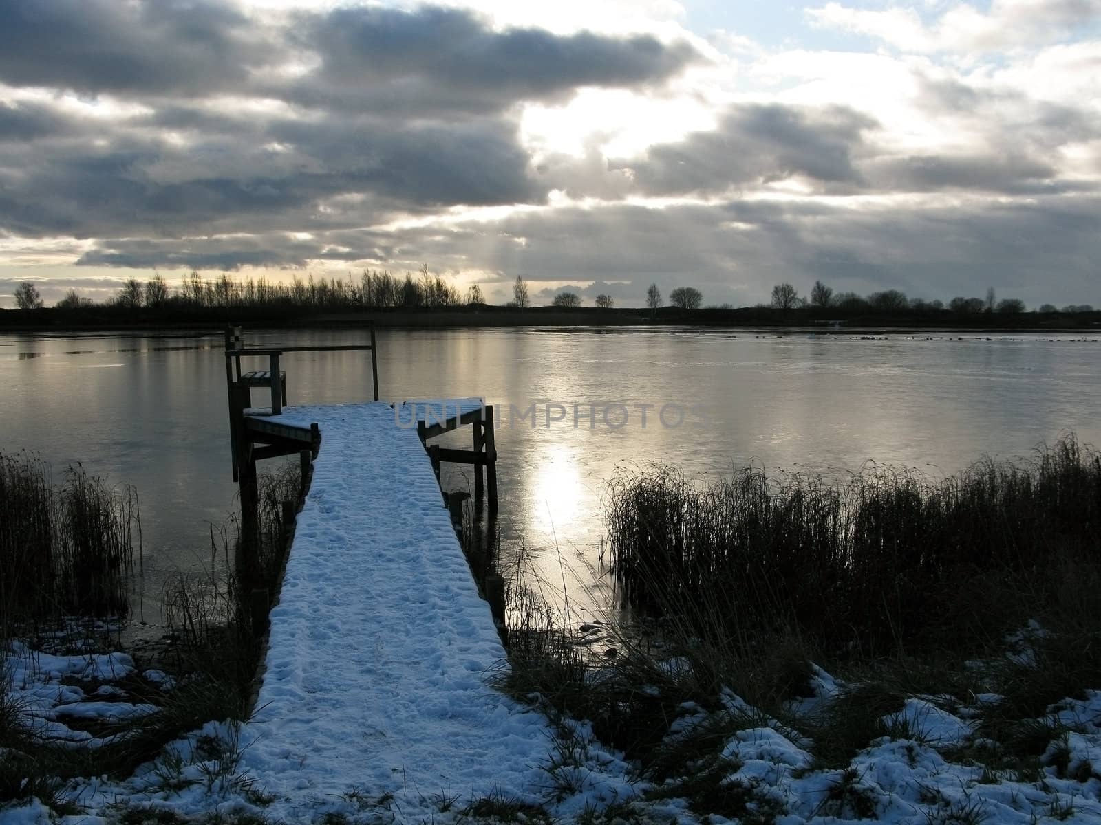 fishing bridge on a frozen lake in winter, covered by snow