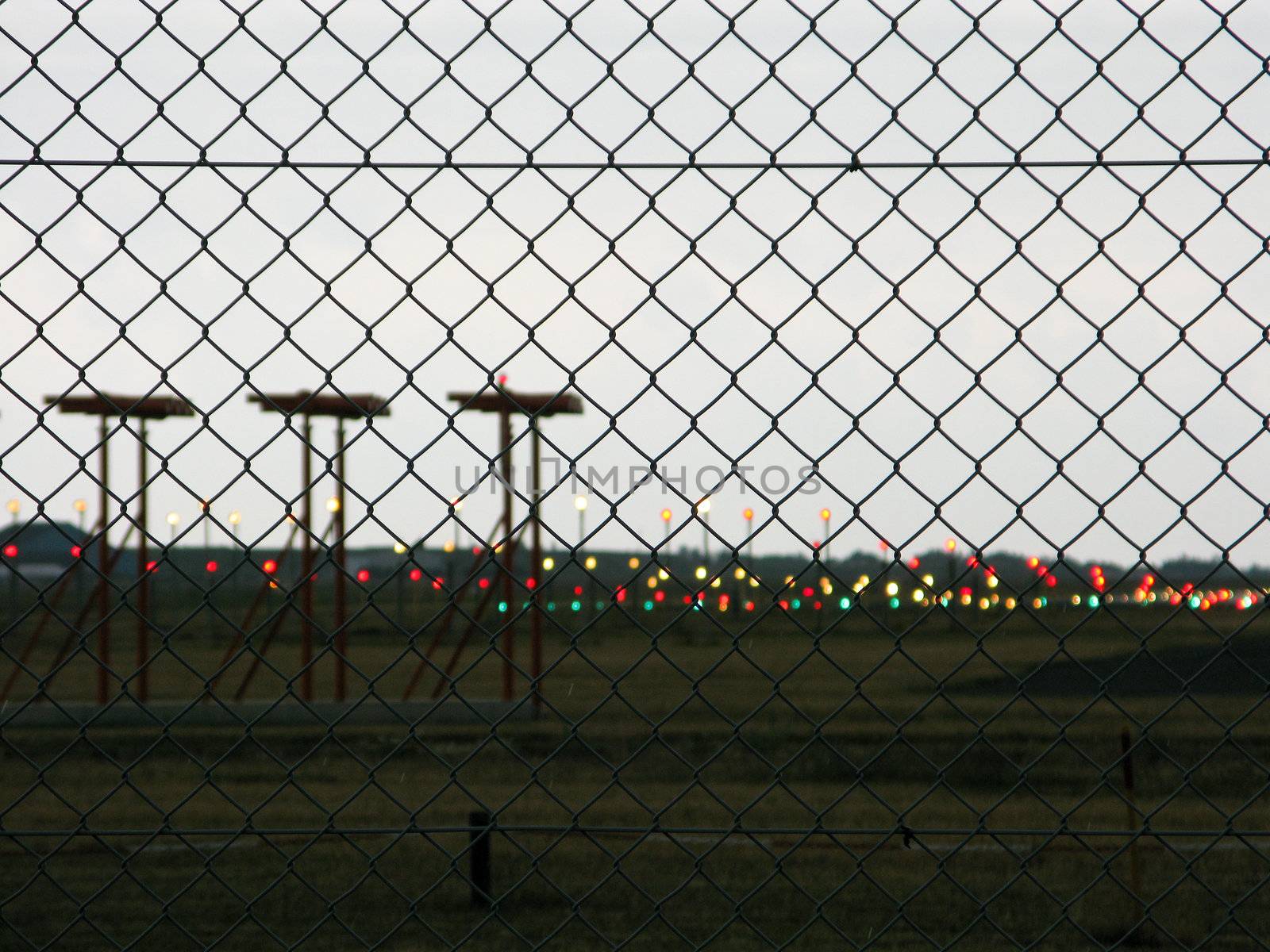 airfield, landing field of an airport seen trough a fence