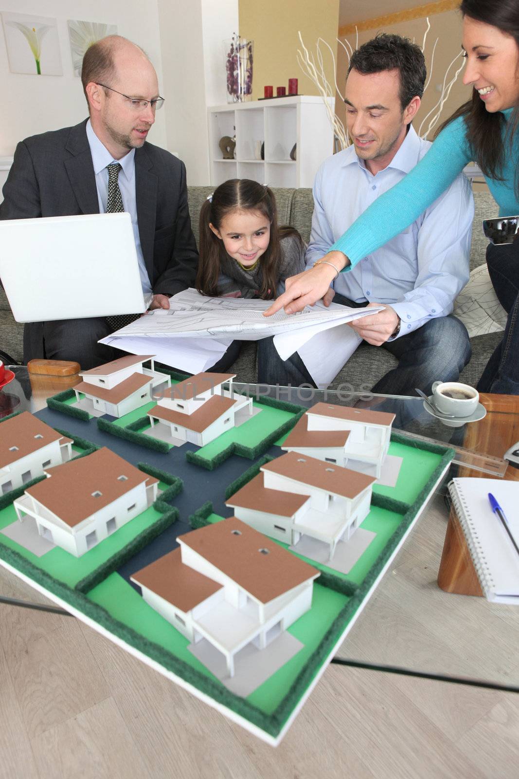 Family discussing a housing development with an architect by phovoir