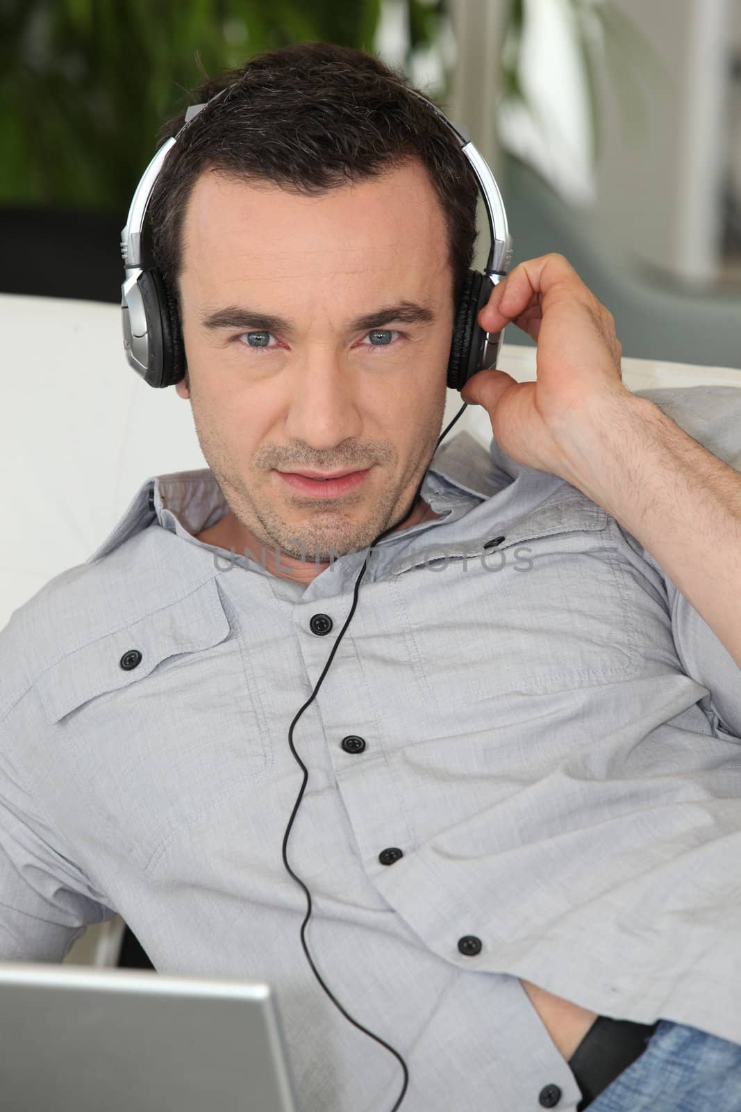 Man listening to headphones by phovoir
