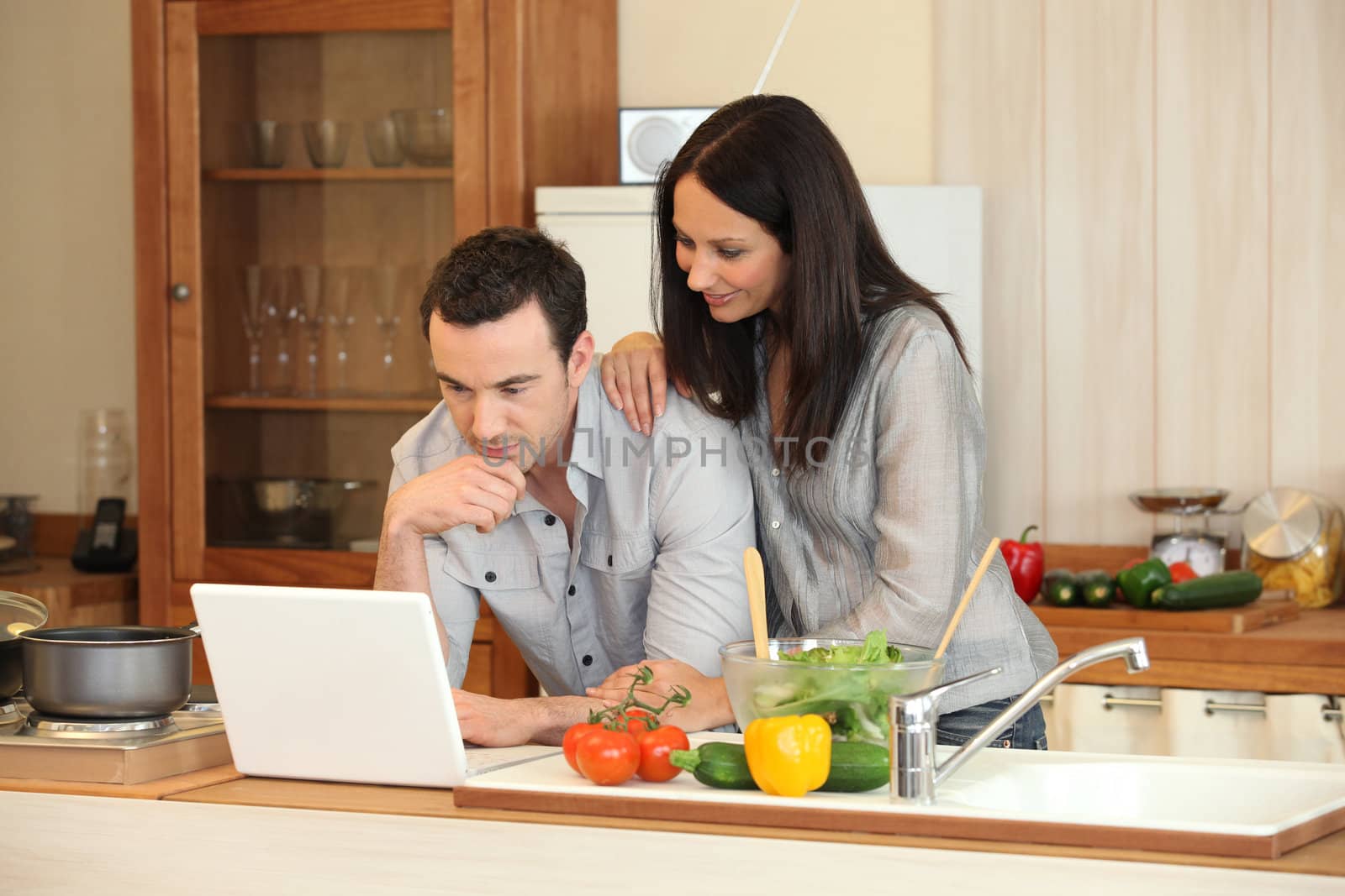 Couple looking at a laptop in their kitchen