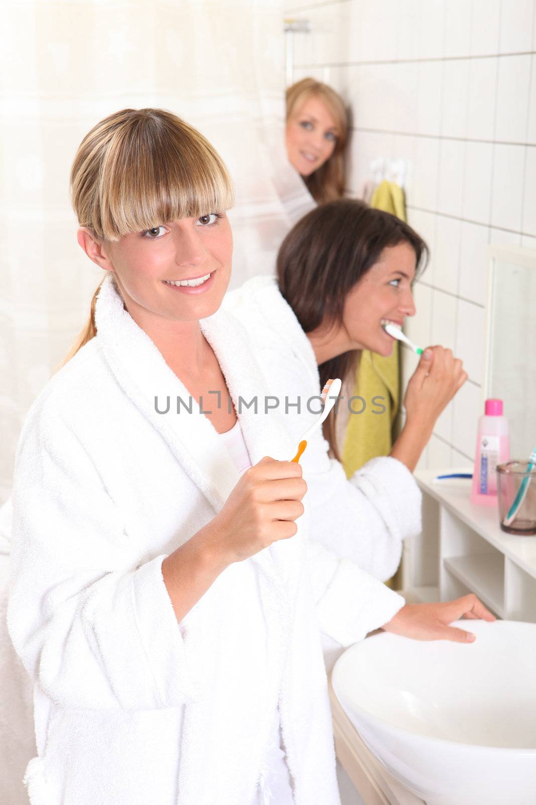 Young women brushing their teeth by phovoir