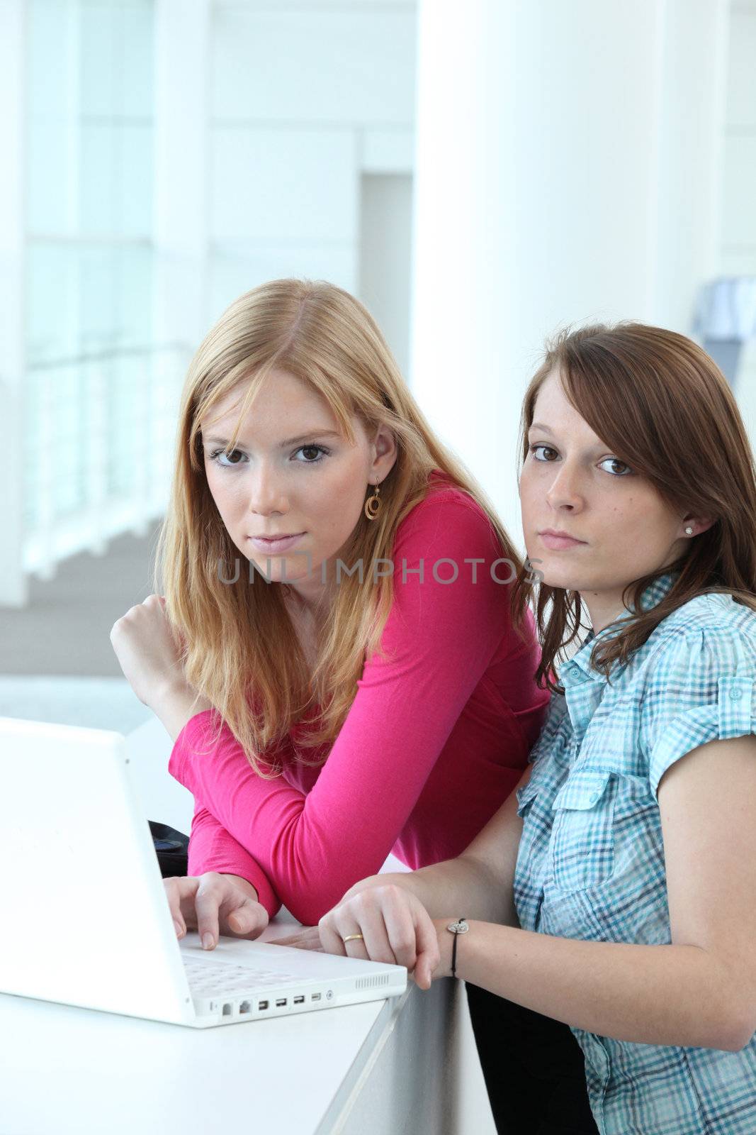 Two teenage girls with laptop computer by phovoir