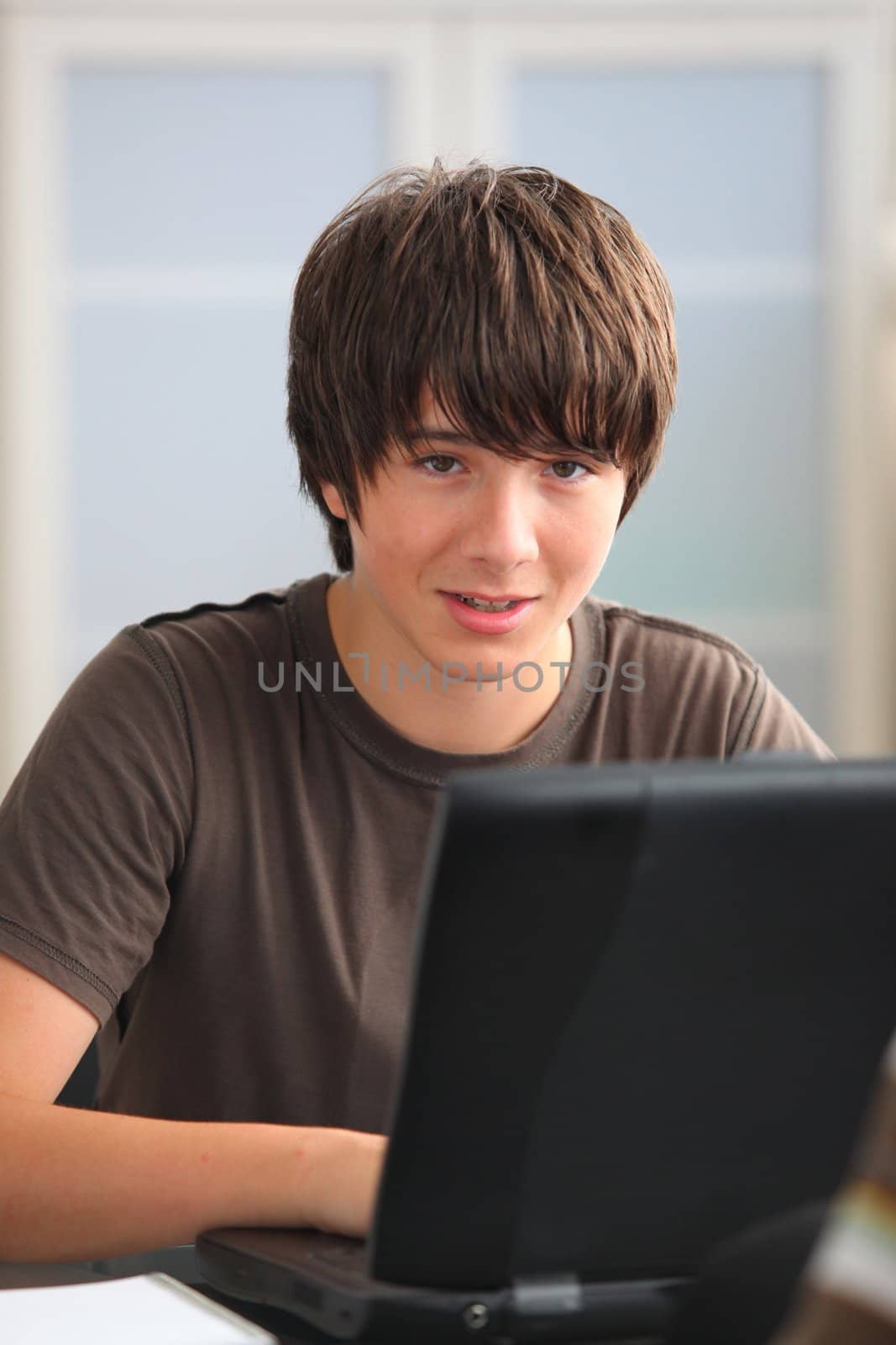 Teenage boy doing his homework on line