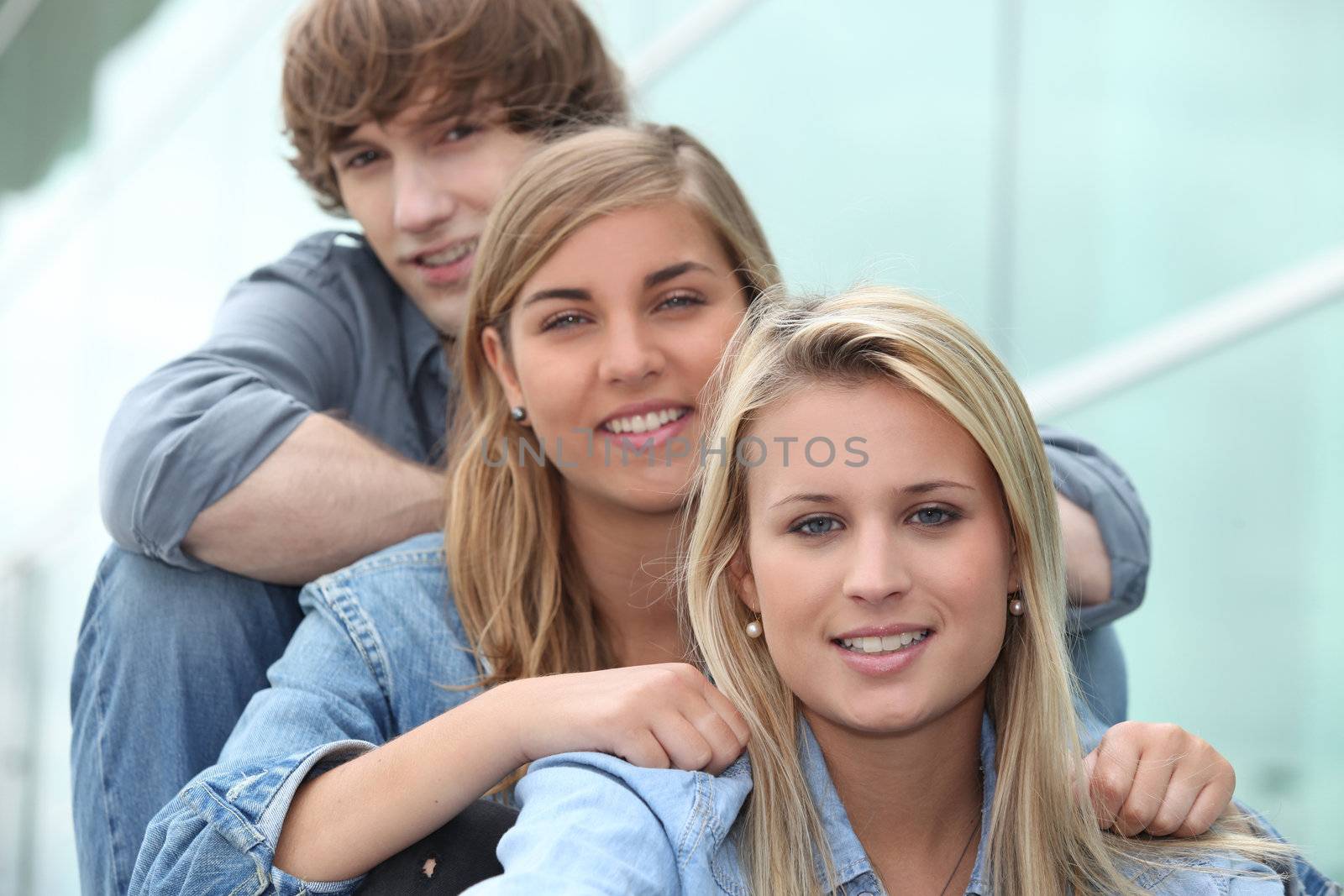 three students sitting in line