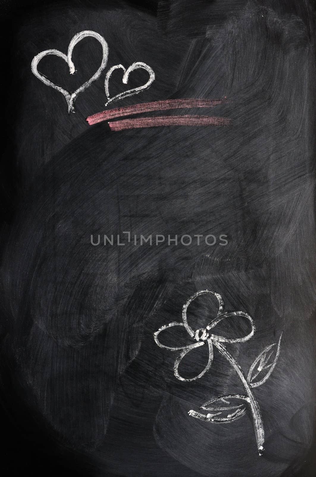 Hearts and flower drawn in chalk on a blackboard