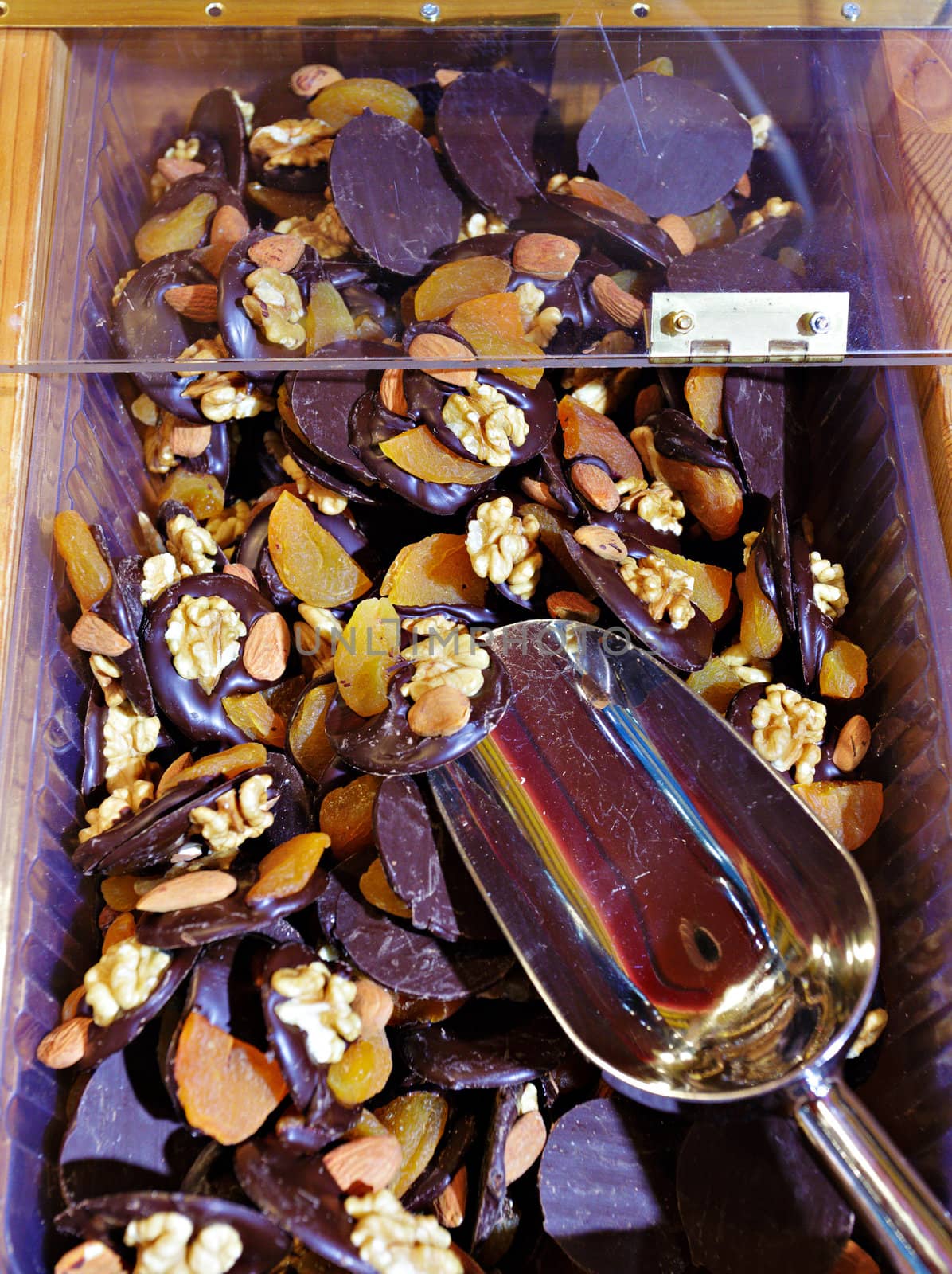 Fruit, chocolate and nuts. Delicious combination on a counter in a store.
