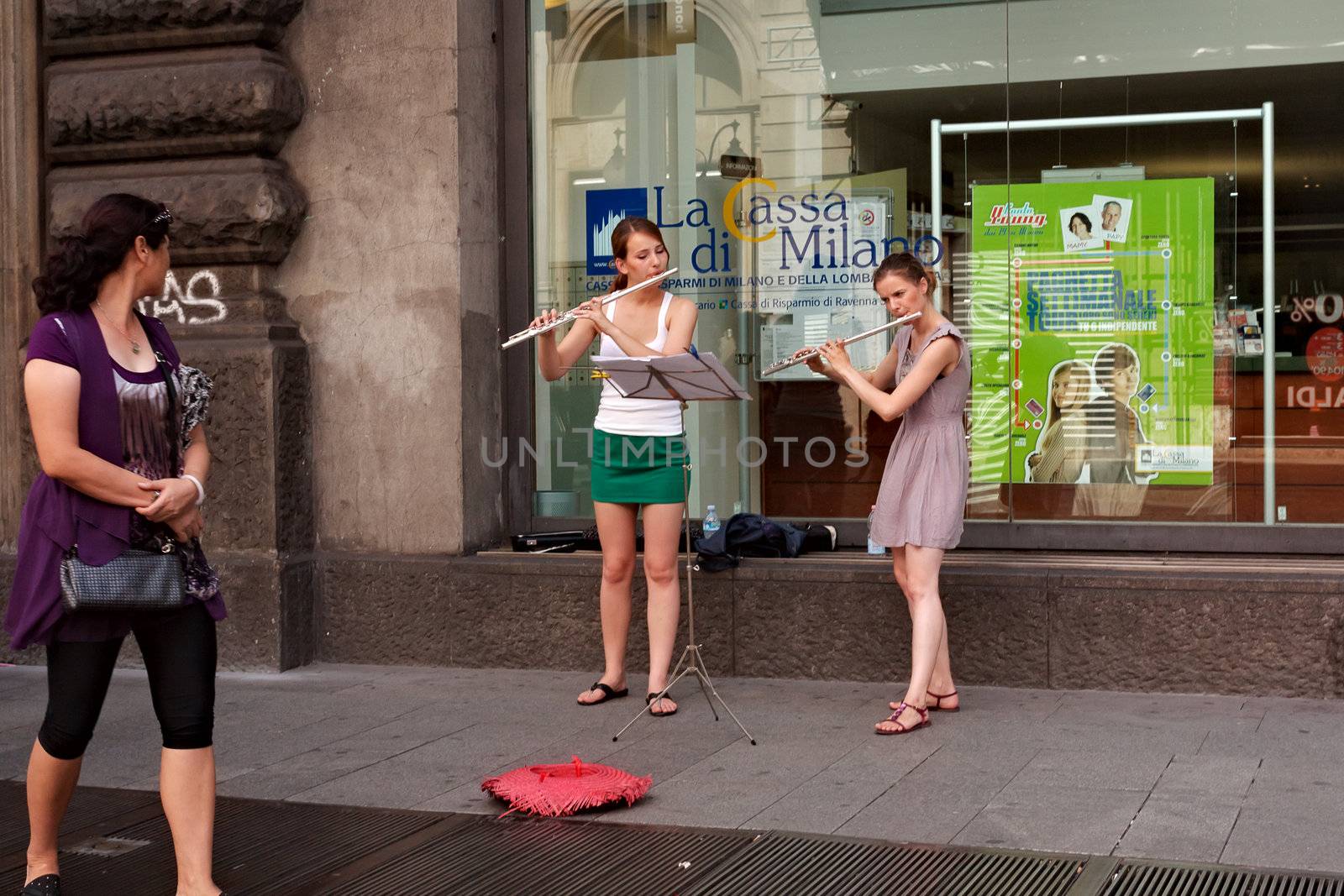 MILAN - AUG, 18: Two girls play the flute in the center of Milan on