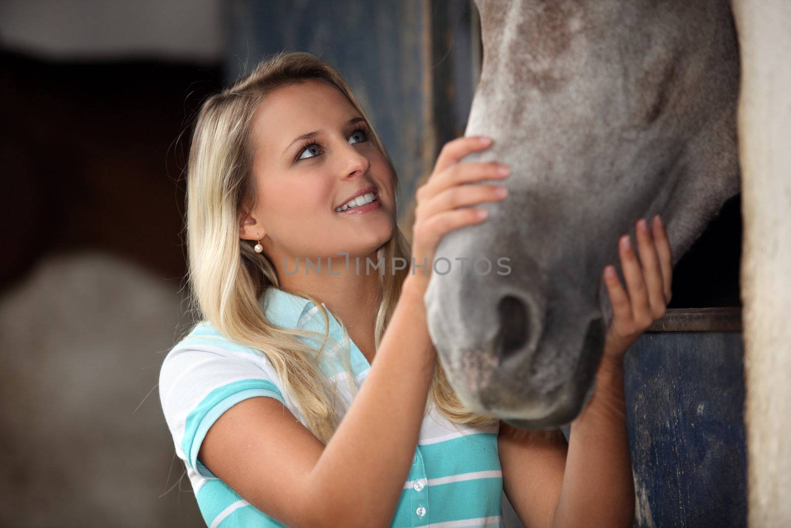 Teen stroking horse