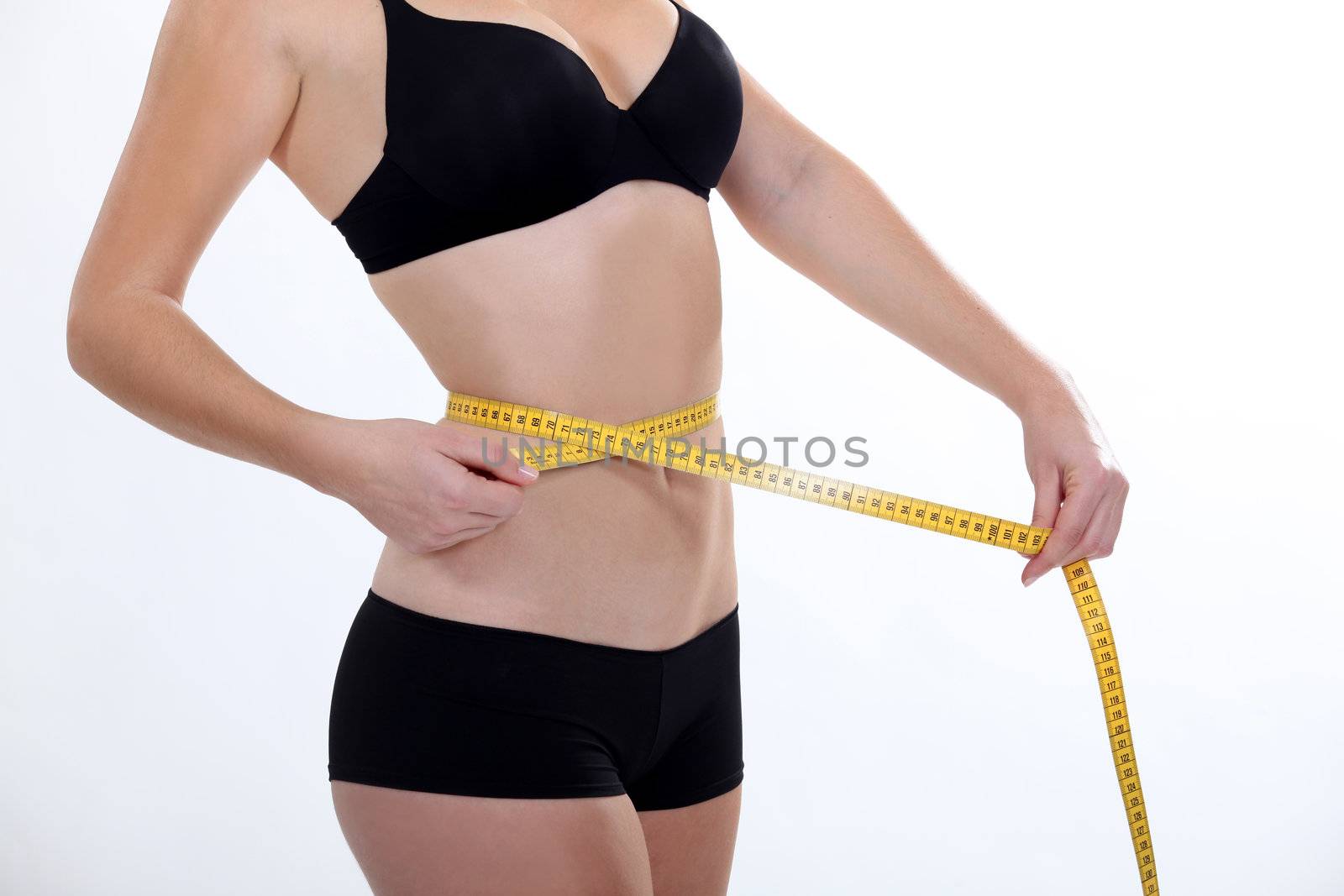 Woman in underwear measuring her waist