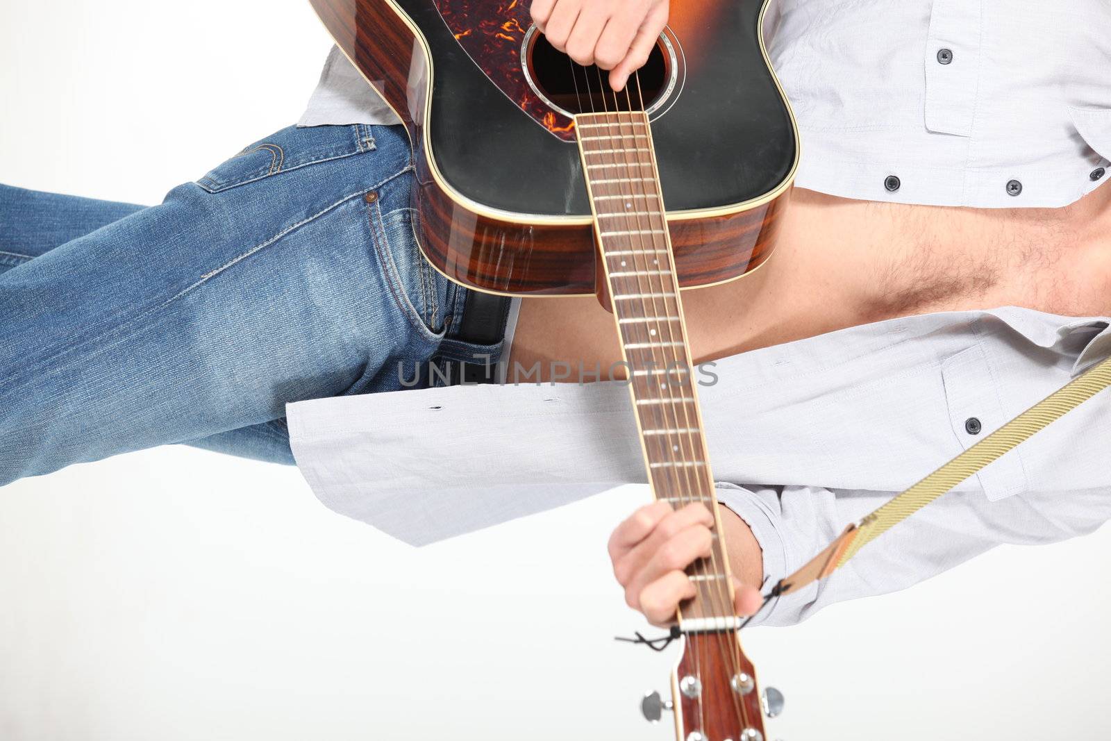 young man playing guitar by phovoir