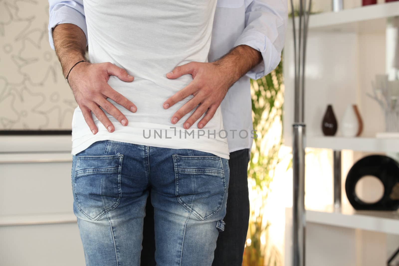 Close-up of couple hugging at home by phovoir