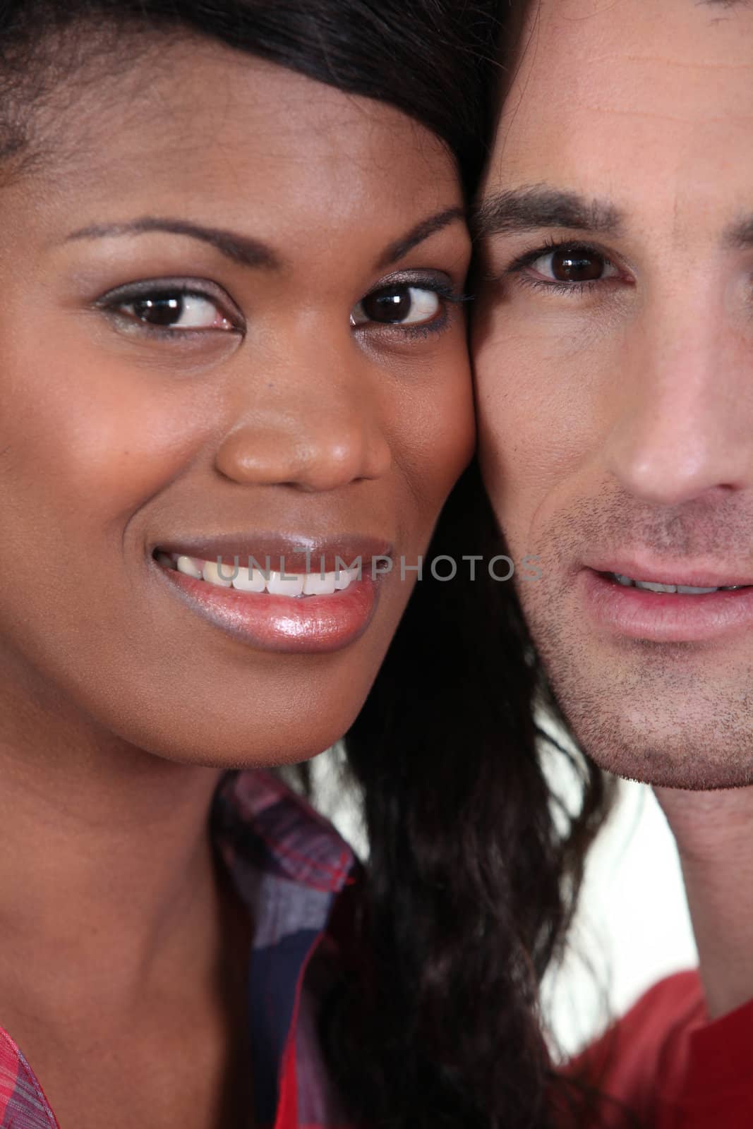 Closeup on the faces of a young couple by phovoir